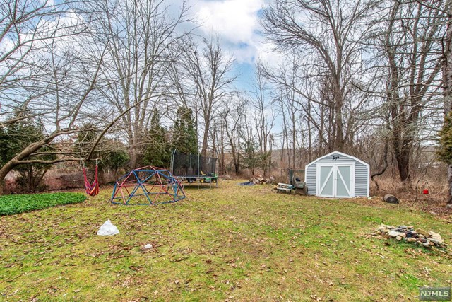 Pet friendly. New hardwood flooring upstairs and 2 full, updated bathrooms. Bi-Level home backed against Jonathans Woods which includes 635 protected green acres. Lots of Generous Room Sizes to Spread Out & Make Your Own! Great living space w/wood burning stove. 2 large bedrooms & full bath upstairs. Large, screened in porch. Super-sized 4th bedroom and office on lower level. Laundry Bonus Room & powder room. Easy space & access to design 2nd full bath. Plenty of storage space in the attic & garage. The backyard is large, level and private. Almost a full acre. An ideal spot to relax & enjoy life. Just a 5 min drive to the bustling Downtown, NYC Direct Mass Transit & easy access to major highways such as 80 & 46. Not a flood zone! Top rated schools. Located towards the end of a quiet, dead end street near walking trails. Great house, great location, great lifestyle.