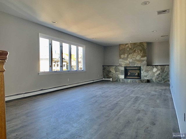 Incredibly spacious, recently renovated Main level of a Bi-Level home. You will enjoy the enormous sun lit family room with a massive gas fireplace; the oversized eat-in kitchen featuring stainless steel appliances and granite counters. Dining area with skylights. Right off the kitchen - convenient access to a large private deck. Large Master suite offering ample closet space and a master bath. Two additional large bedrooms. New floors throughout, central AC, baseboard heat. Use of attached garage plus 2 outside parking spaces. Laundry room on the ground floor. Shared use of a large backyard. Most convenient location: short distance to the train, schools and shopping. No pets.