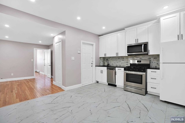 Located in the best section of Union City known as West Hoboken. Completely renovated apartment featuring 2 Bedrooms and 1 Full Bath will sure to please with direct access to the backyard, parking, and a shared washer and dryer in the basement. Step into the open layout kitchen, living room, and dining room with all new floor tile and original hardwood floors throughout, large open kitchen w/custom white cabinetry & tile backsplash, recessed lighting, and access to the private backyard. The primary room features 3 large windows w/an original fireplace, 2nd bedroom w/direct access to the outdoor space, & a full bathroom w/a walk-in shower. Included in the home: 1 car parking, W/D room in the basement, and private access to the backyard to enjoy the outdoors during the warmer months. Located right next to Washington Park, enjoy the dog park, tennis courts, soccer field, grocery store, and steps away from major NYC transportation. Walk to Hoboken light rail from Palisades Ave.