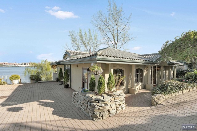 Welcome Home! This custom built river front home has a secluded beach, unobstructed panoramic views of NYC & the GWB. Located in the prestigious & private Edgewater Colony this home features 4 bedroom, 3.5 bathrooms, high ceilings, radiant heated floors and other amenities spread throughout. Upon entering into the entry foyer on the main level you're met by a grand salon with exposed heavy timber natural framing, custom kitchen, large formal dining room, living room with fireplace, guest bathroom, game parlor and media room. French custom doors lead to the covered balcony with outdoor kitchen and river/NYC views. The second level features a large principle suite w/ travertine heated floors, a large custom walk in closet for two, sunken jetted tub with separate shower and duel sinks, floor to ceiling windows and french doors lead to another balcony and more river/ NYC views. A second ensuite bedroom, two additional bedrooms, bathroom and utility rooms complete this home.