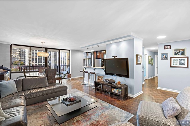Experience luxurious living in this exceptional condo, boasting a contemporary design. As you enter, you'll immediately notice an abundance of natural light coming through the sliding doors to the terrace, featuring picturesque views of the garden & NYC skyline. The seamless, modern open-floor plan effortlessly connects the living room, dining room & the stylish open-concept kitchen. The kitchen features sleek modern cabinetry, granite countertops, a wine fridge, stainless steel appliances, & a breakfast bar. The unit features two generously-sized bedrooms, including the primary suite. The primary bedroom has ample space, complemented by a walk-in closet with custom shelving & a luxurious full bathroom with a jetted tub, and dual vanities. The second bedroom boasts tons of space, with an adjacent second full bath featuring chic modern updates. This full-service building offers amenities including a pool, playground, tennis & basketball courts and on site state gym. Don't miss it!
