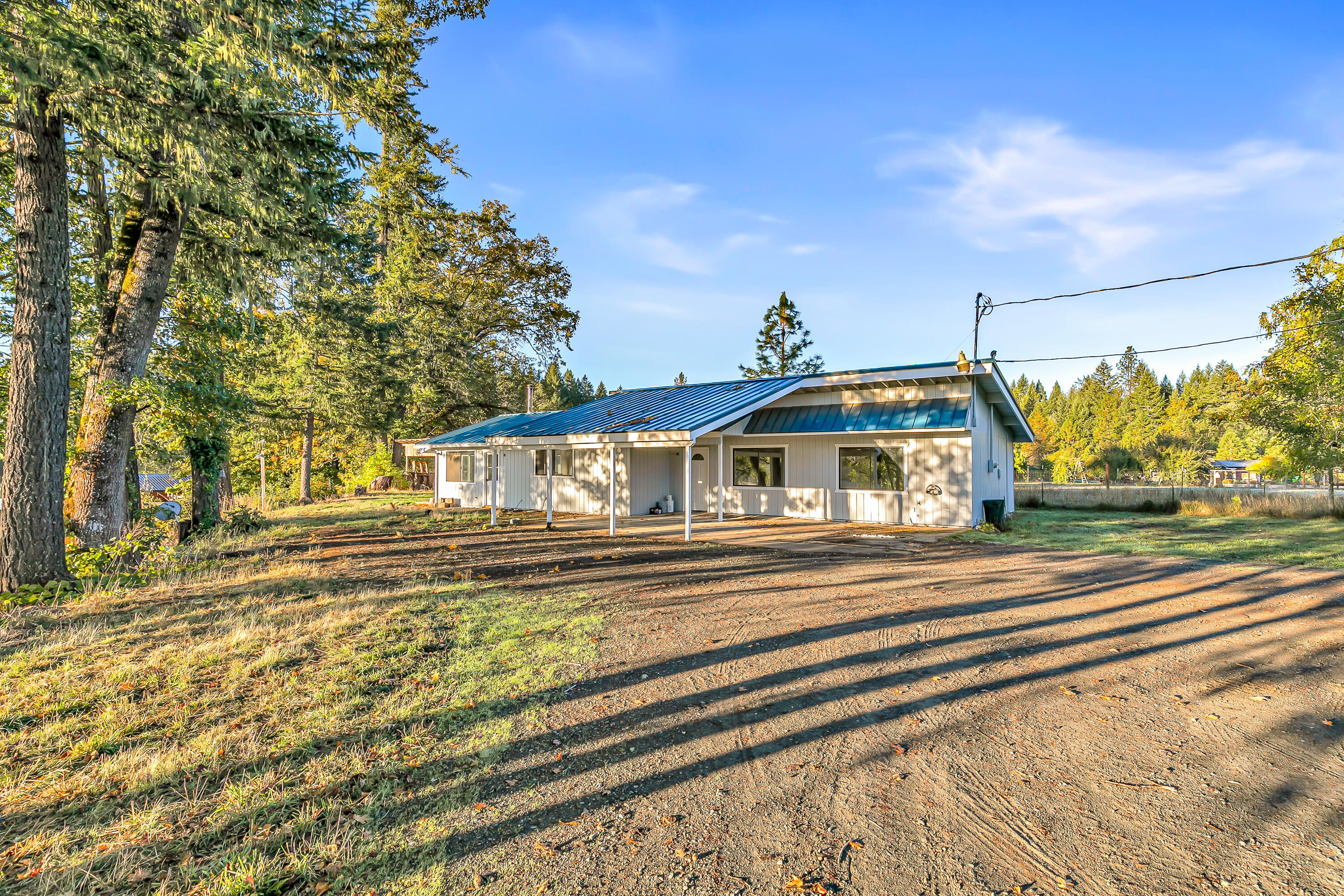 Looking for a low maintenance ranch property at an affordable price? If so, this is the one for you! Within 10 mins from downtown Cave Junction, this property features a single level, 3 bedroom, 2 bathroom, 1570 sq ft home w/ a metal roof, walk-in closet in the primary bedroom, walk-in shower, walk-in pantry, woodstove in the living room, spacious kitchen, laminate flooring, and various touch ups throughout. For anyone interested in farming this property also features 5+ usable acres (all pasture), detached shop (27x30), detached 2 car garage, pole barn, gated entryway, & much more! Perfect opportunity for anyone wanting to raise their family in a beautiful Southern Oregon setting while starting a farm on a small or large scale. This one won't last long on the market, so contact your agent today for a personal tour, before it's too late!