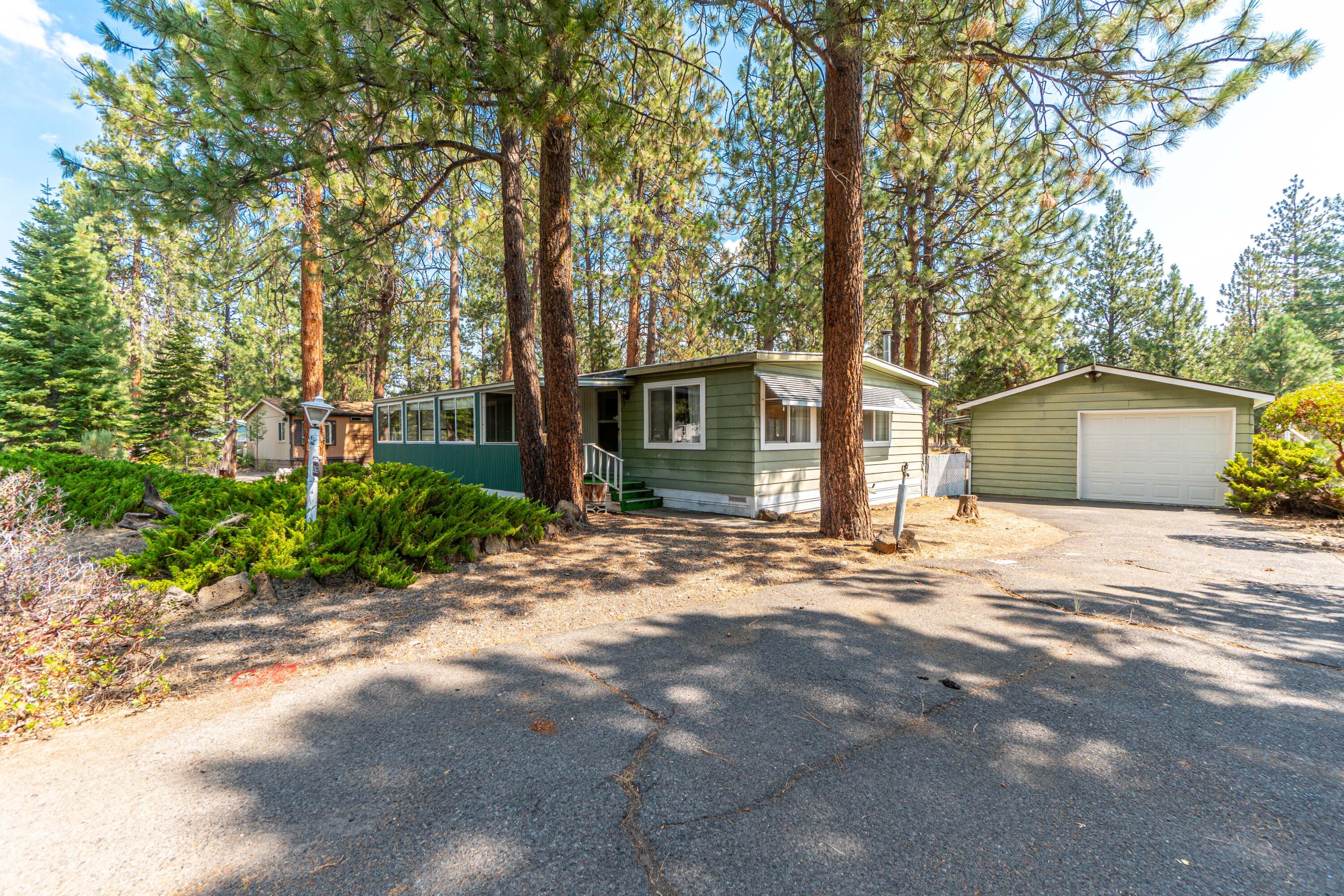 This charming 2-bedroom, 2-bath home on a spacious .36-acre lot offers the perfect blend of cozy cabin vibes and modern convenience. Only the second owner, with a well-maintained and clean interior, you'll feel right at home surrounded by natural wood accents and warm finishes. The property features a detached stick-built garage, ideal for storage or a workshop. Backing to open space, you'll enjoy peace and privacy while still being just minutes from town with great access to all the adventure that Bend life has to offer. Whether you're looking for a lovely place to call home or a promising investment opportunity, this property is a rare find with great potential. Roll up your sleeves and place your own personal touch on this gem. Don't miss out—schedule your tour today!