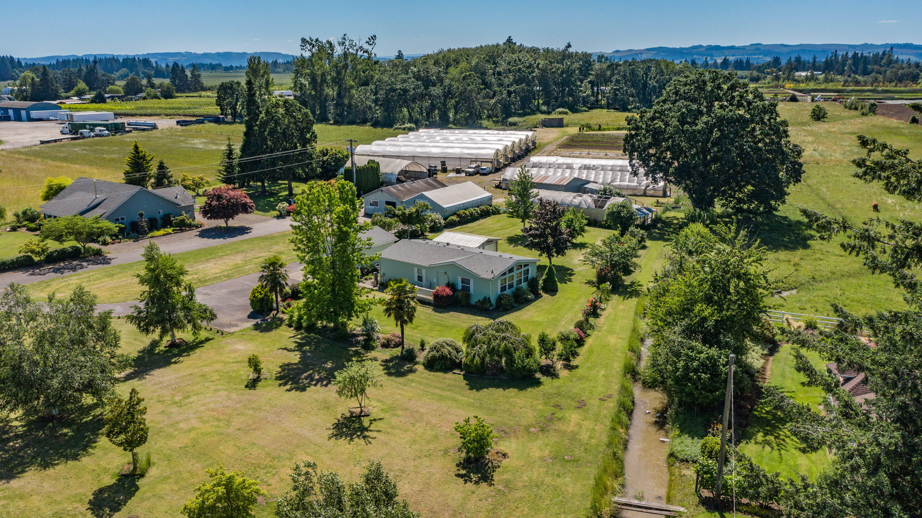 So many potential agricultural income streams with this outstanding property.  The sky is the limit with one newer house, a hardship home, almost half an acre under the 6 bay Nexus gutter connect greenhouse and several other useful outbuildings to support your business and/or habits. 80 gpm irrigation well, Amity soils, plenty of garden space and room for your animals. The updated main house is a roomy quiet retreat from your busy day w/ a huge great room, large covered porch and inviting back yard.
