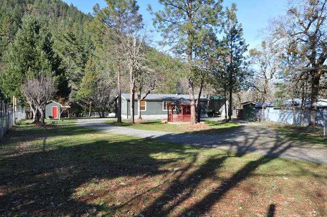 Well kept and maintained home on .75 of an acre with Murphy Creek running through the property.  Move in ready, this split floor plan has 3 bedrooms/2 baths, walk-in closets and features a cozy wood stove for the winters and a new heat pump for summer cooling.  As you enter the gated property you'll find a circular driveway, Gazebo built in 2020, RV carport, garden/tool shed, small workshop and pump house, many fruit trees and the trail to the creek.  Home has Sensor lights on all sides. There is a leased propane tank and all appliances stay.. Call today to preview this exceptional home