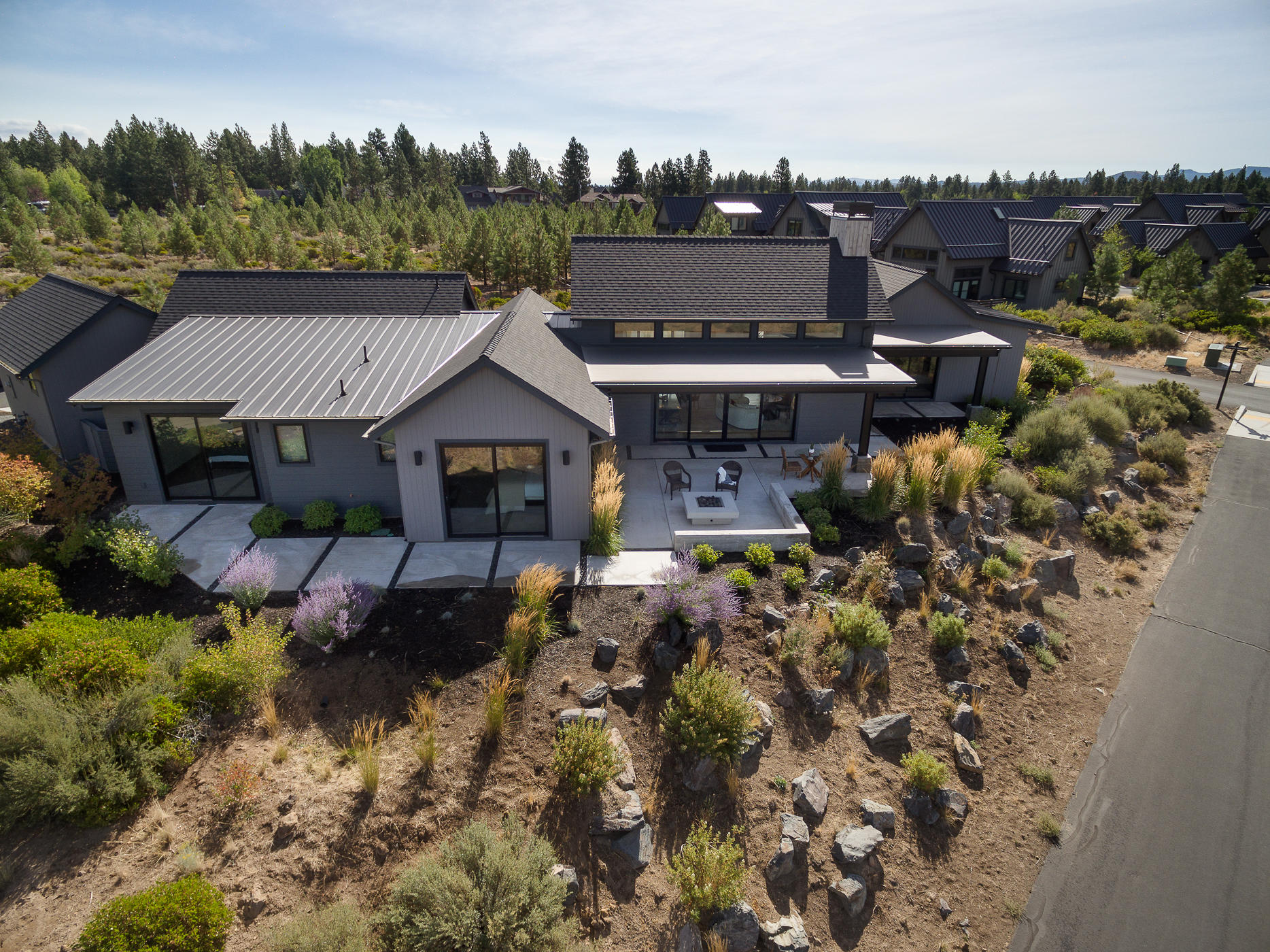 Welcome home to Tetherow, one of Bend's most desirable golf communities. Gorgeous Cascade Mountain views from every room in this beautiful single story modern farmhouse. Floor to ceiling windows let the natural light in and show off the expansive views in every direction. The gourmet kitchen will satisfy the most discerning chef. A large island for casual meals. Vaulted ceilings and transom windows over both sides of the great room. Hardwood floors throughout with heated bathroom tile floors. The master suite has a large walk in closet, soaking tub and tiled shower. Nice separation of the master and 2 junior suites on opposite sides of the home. Incredible outdoor living spaces, sit around the fire pit and enjoy the Cascades or relax in the court yard and overlook the common
area. The mud room leads to the spacious 3 car garage, lots of room for cars and toys!