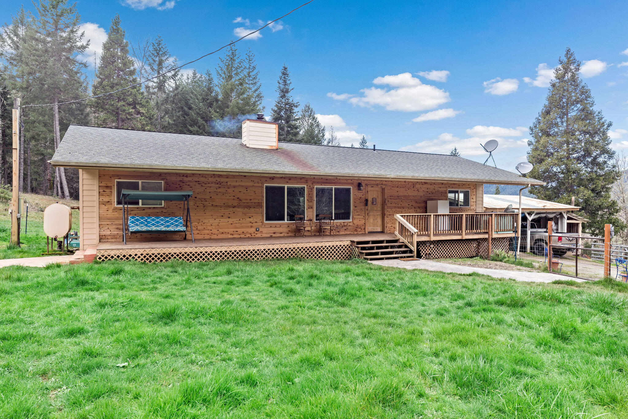 Drive along the country road into the private home setting - head up the stamped concrete to the full length deck, great open floor plan home w wood and kerosene heat, granite counter tops in kitchen & so much more, 101 acres for your animals & privacy. Newer septic, 2 ponds, shop, barn, hay storage & multiple out buildings. Fenced & Cross fenced. 2 pear, a few apple and other fruit trees. 2 car carport attached and 2 car carport detached - room to park vehicles & trailers. Small chicken pen also.