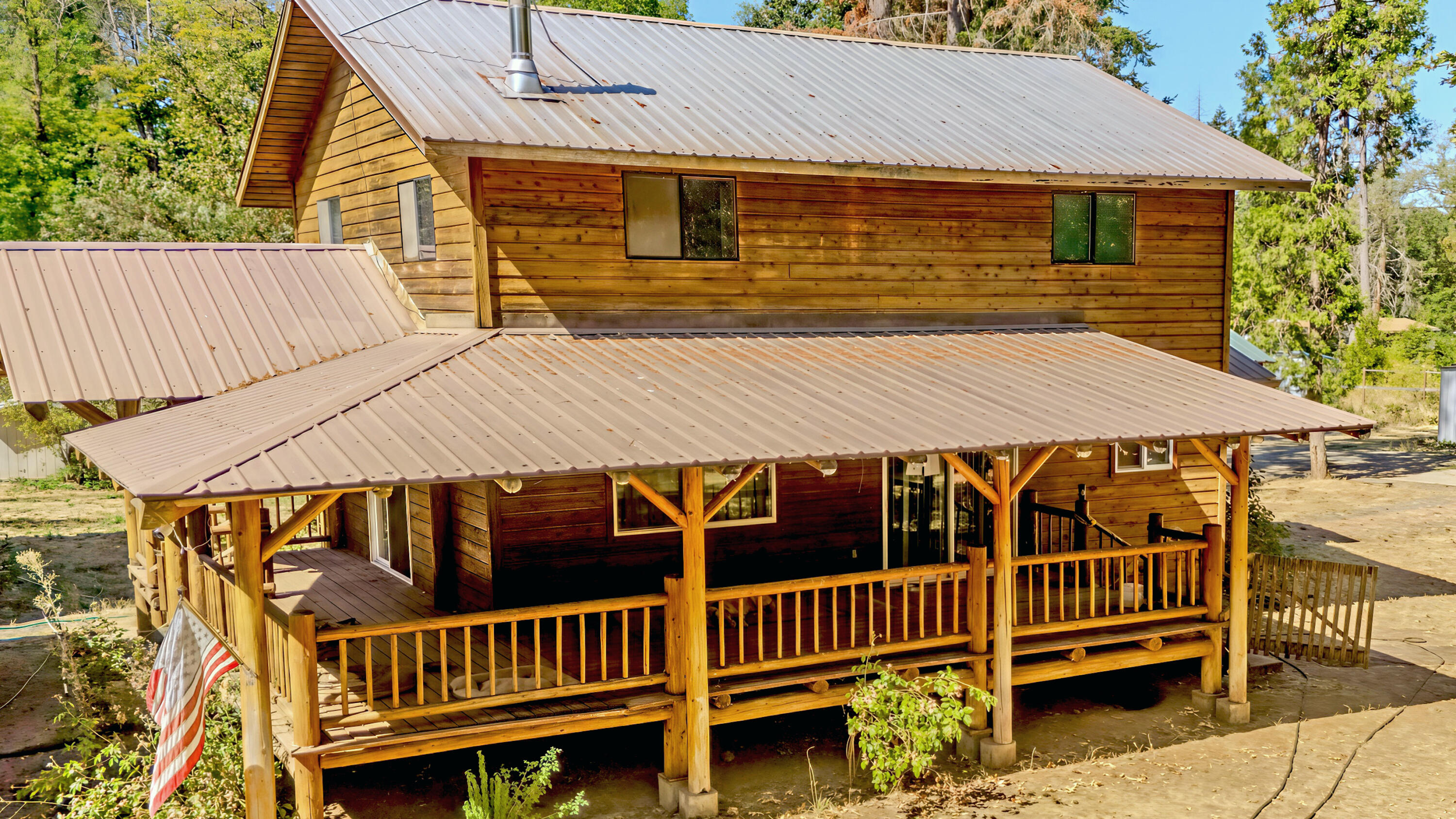 This is the creekfront hobby farm you've been waiting for!  Step inside this 2-story Pacific Northwest cabin-style 1,548 sq. ft home with 3 bedrooms and 2 bathrooms on 5 flat acres. Inside, rich tongue-and-groove wood walls and ceilings exude rustic charm, blending seamlessly with modern comforts. Unwind on the handcrafted log spindle deck, soaking in the peaceful country setting.  Embrace serenity by your private pond and scenic Elder Creek frontage, perfect for quiet evenings. Bring the RV! This property is road-tripper approved with RV hookups.  Expansive pastures and thriving apple trees invite gardening or livestock ventures, while a 2-story barn, durable sheet metal-sided workshop, and multiple outbuildings offer ample storage for hobbies or projects.  This property embodies the essence of a nature-inspired lifestyle. Don't miss the chance to own this treasure—schedule your private tour today!