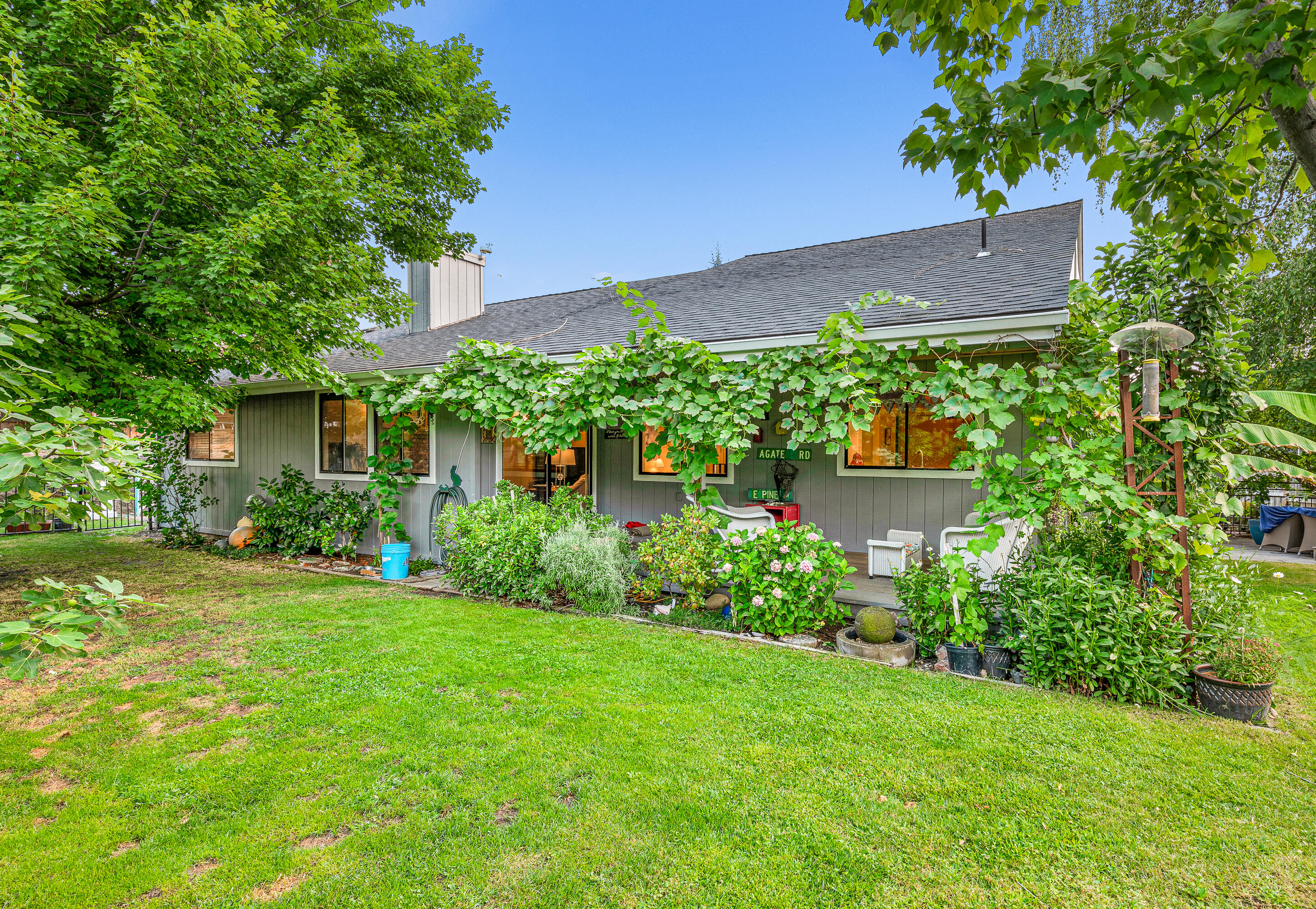 Lovely upgraded East Medford home with serene and private backyard gardens, located in a desirable cul-de-sac nearby Centennial Golf Club, St. Mary's School, and Asante Medical Center. Main level features Saltillo tile floors, high vaulted ceiling with cedar paneling, brick hearth with certified wood-burning pellet stove, covered back porch, formal and informal dining areas, gourmet kitchen with beautiful soapstone counters, maple cabinets, stainless appliances including a 4-burner gas Jenn-Air range and convection oven, master with dual closets and en-suite bath with tub/shower, full guest bath with shower, laundry room, and 2-car garage. Upper-level has over 600 SqFt of studio office space, excellent for home base business or work from home. Landscaped grounds with fruit-producing trees, grass lawns, patio, wisteria arbors, raised beds, greenhouse, and storage shed. New high-efficiency furnace, central air conditioning system, and fresh exterior paint in 2020; new roof in 2015.