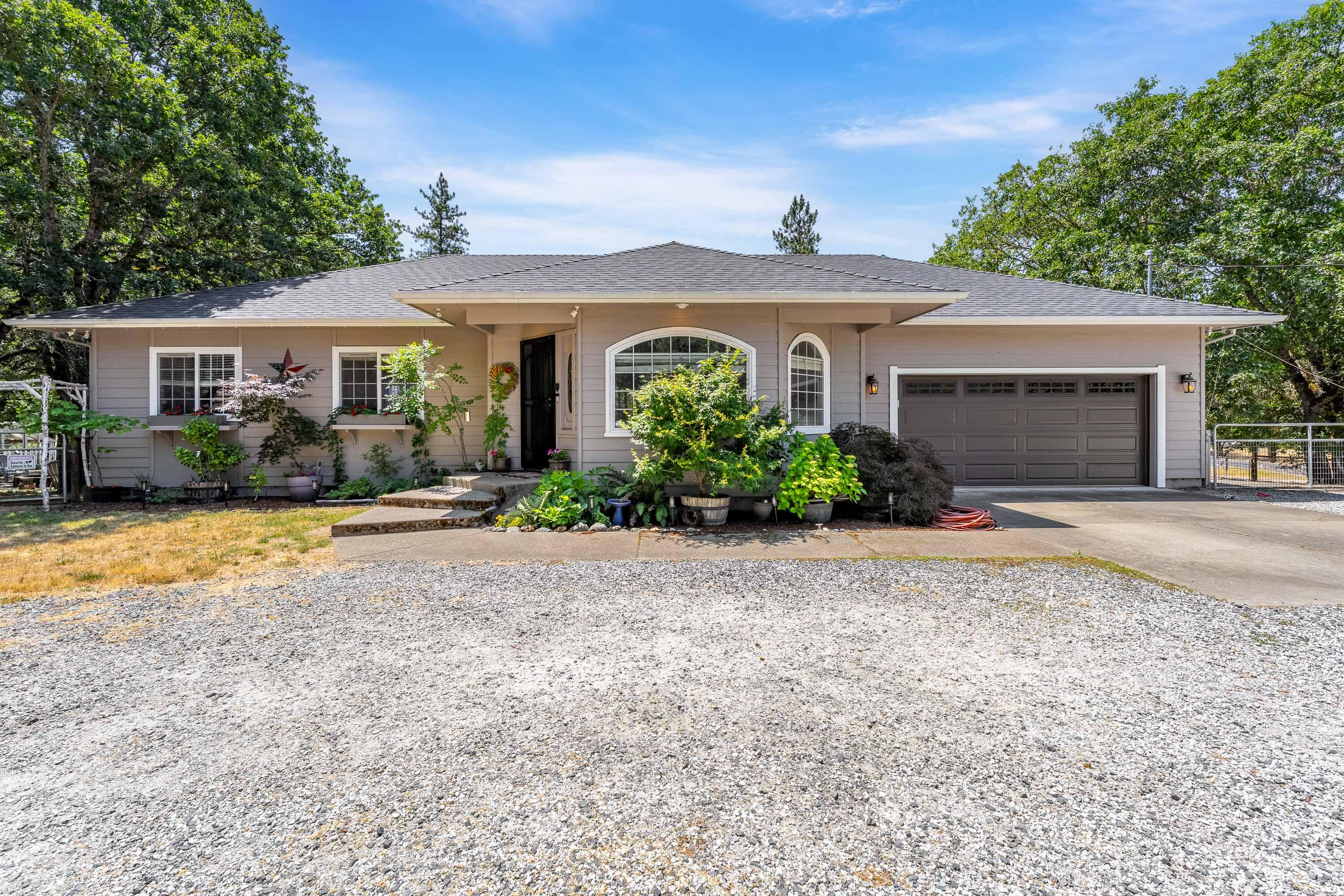 Modern comfort meets country charm in this beautifully updated single-level home with a bright, open layout, vaulted ceilings, and LVP flooring throughout. Large living that flows into dining and kitchen. The kitchen has recent updates including refinished cabinets, granite and ss appliances. The primary bedroom is a true retreat with access to the covered deck, walk-in closet, and fully updated bathroom including tile floors, tile shower, and new vanity. There are 2 more bedrooms and another fully updated bathroom. Enjoy the outdoors with a covered deck, fire pit, above-ground pool, chicken coop, fenced garden, and greenhouse. The 2-car garage includes a bonus room ideal for a home office, gym, or extra storage. A circle driveway offers plenty of parking and easy access. The property is fully fenced, cross-fenced and offers extra security with an electric gate. All located on a peaceful, usable 1.37ac property with great proximity to the I-5. Come explore the possibilities!