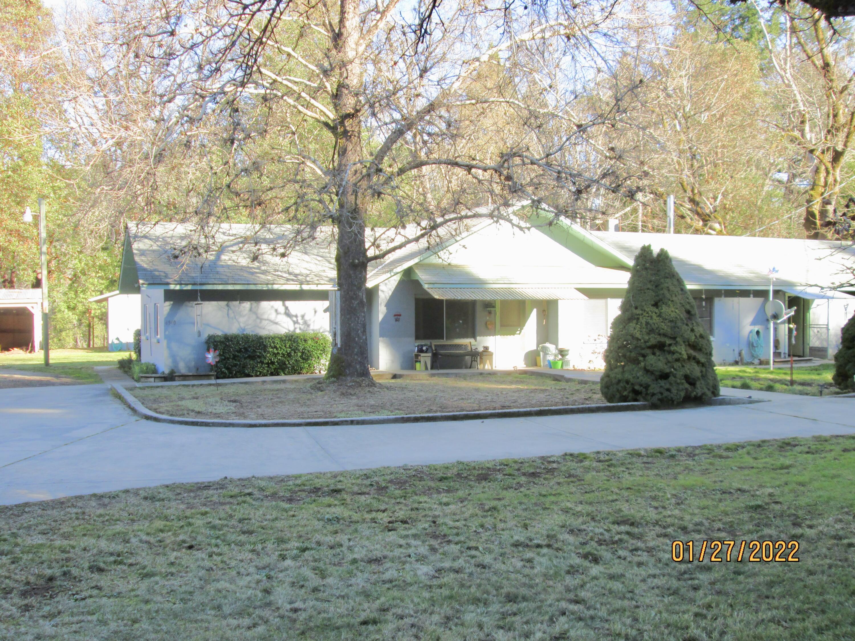 This is the chance to own a wonderful 5+ acres in the Illinois Valley.  The property features a 4 bedroom 2 bathroom cinderblock house surrounded by lawns, trees and accompanied by many outbuildings and a pasture on the top level and a nice meadow bordered  by a creek on the lower level.  The meadow is accessed either by stairs on one side or a lawnmower/ tractor ramp on the other. This property even has a root cellar!!!
The outbuildings include one with a shop, covered parking and a walk-in freezer (has not been used in the past 5 or 6 years), another that was a chicken egg collecting and processing building with a coop and a walk-in fridge (not used in the past few years).  There are many other outbuildings, including a semi-trailer with a permanent roof and power that was used for storage and an old travel trailer and much much more.  You really must see this one to appreciate it.
