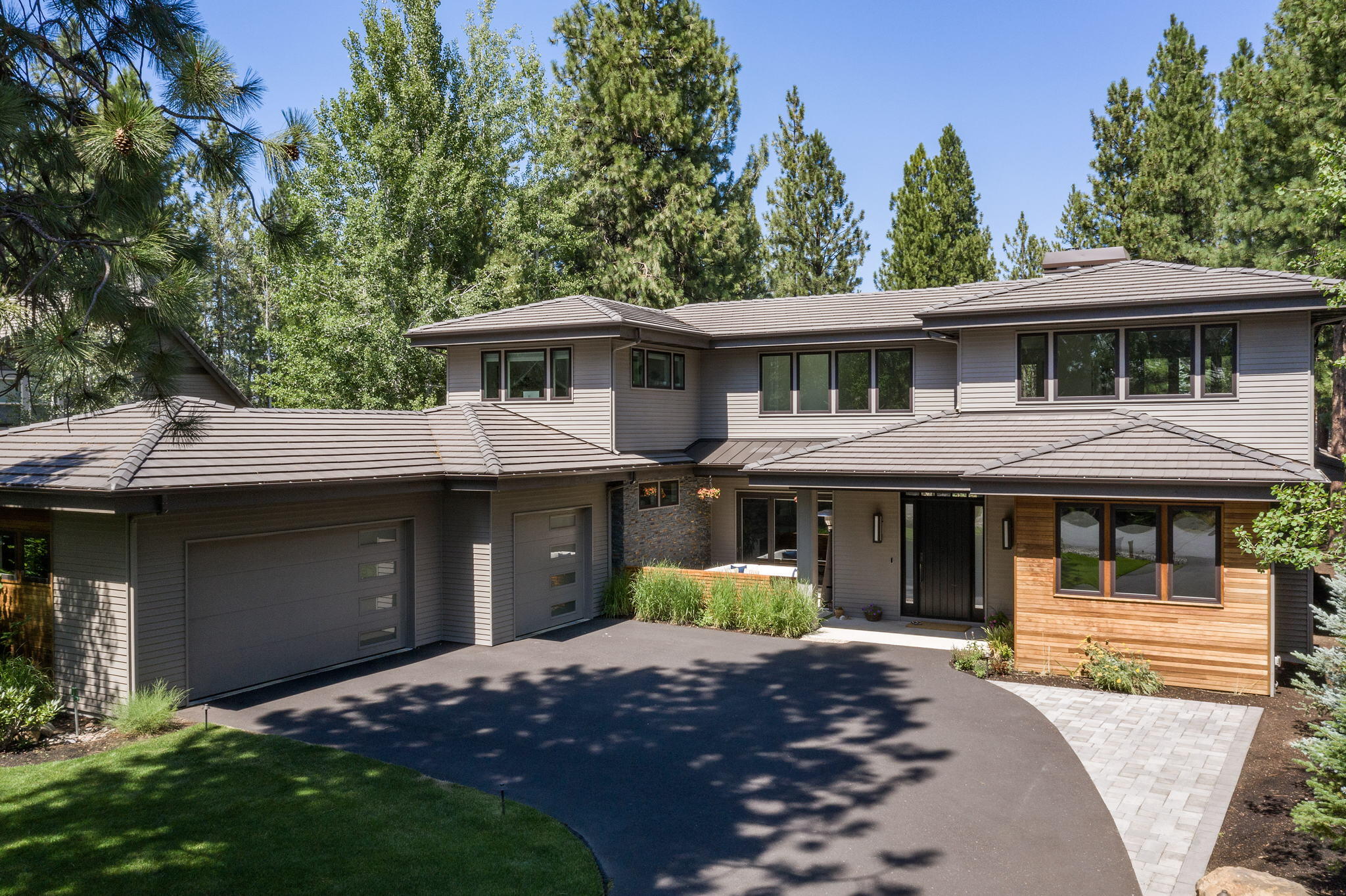 This modern contemporary Broken Top home begins at the welcoming front patio, leading the way into the bright and airy interiors benefitting from an expansive accordion glass wall in the great room that opens to spacious outdoor living area, complete with bbq kitchen/dining/lounging spaces, hot-tub patio, & lower patio firepit seating overlooking the cascading waterfall and pond. Back inside, the bright and cheerful kitchen will inspire the gourmet chef in the family with top-of-the-line appliances, enormous walk-in pantry with a kegerator & beverage fridge. The main level primary suite overlooks lovely garden & waterfall views and encompasses a truly luxurious bath. Main level also features a second full en-suite bedroom, as well as two separate offices. Upstairs is home to two addtnl spacious guest rooms and comfortable family room, the perfect retreat for family and guests. Stunning home spans 4,221 sq.ft. on a nearly ½ acre private oasis, set within the gated Broken Top community.