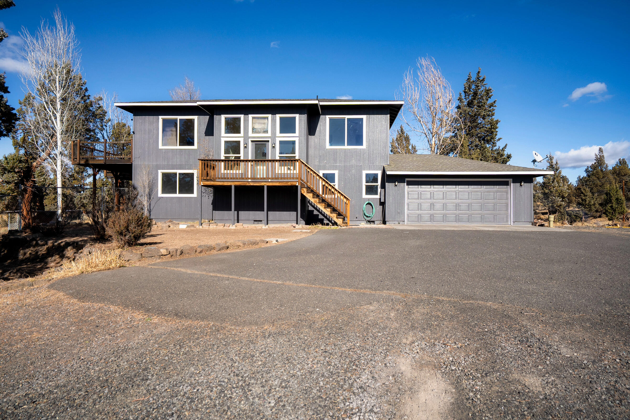 Discover this beautifully appointed home on 4.05 acres in the desirable Tetherow Crossing community. Just minutes to BLM land and the Deschutes River for swimming, fishing, and kayaking, plus quick access to Redmond. The split-level design offers an open kitchen, dining, and primary suite upstairs, with a large deck showcasing stunning Cascade views. Downstairs, find two bedrooms, a full bath, family room with wood stove, and generous laundry area. Step out to the fenced backyard with hot tub for ultimate relaxation. The home is move-in ready. An attached 2-car garage plus a 36x48 ft insulated shop with concrete floors, two 14' doors, and 220 power provide room for hobbies, storage, or future projects. Plenty of space to expand and enjoy Central Oregon living at its best!