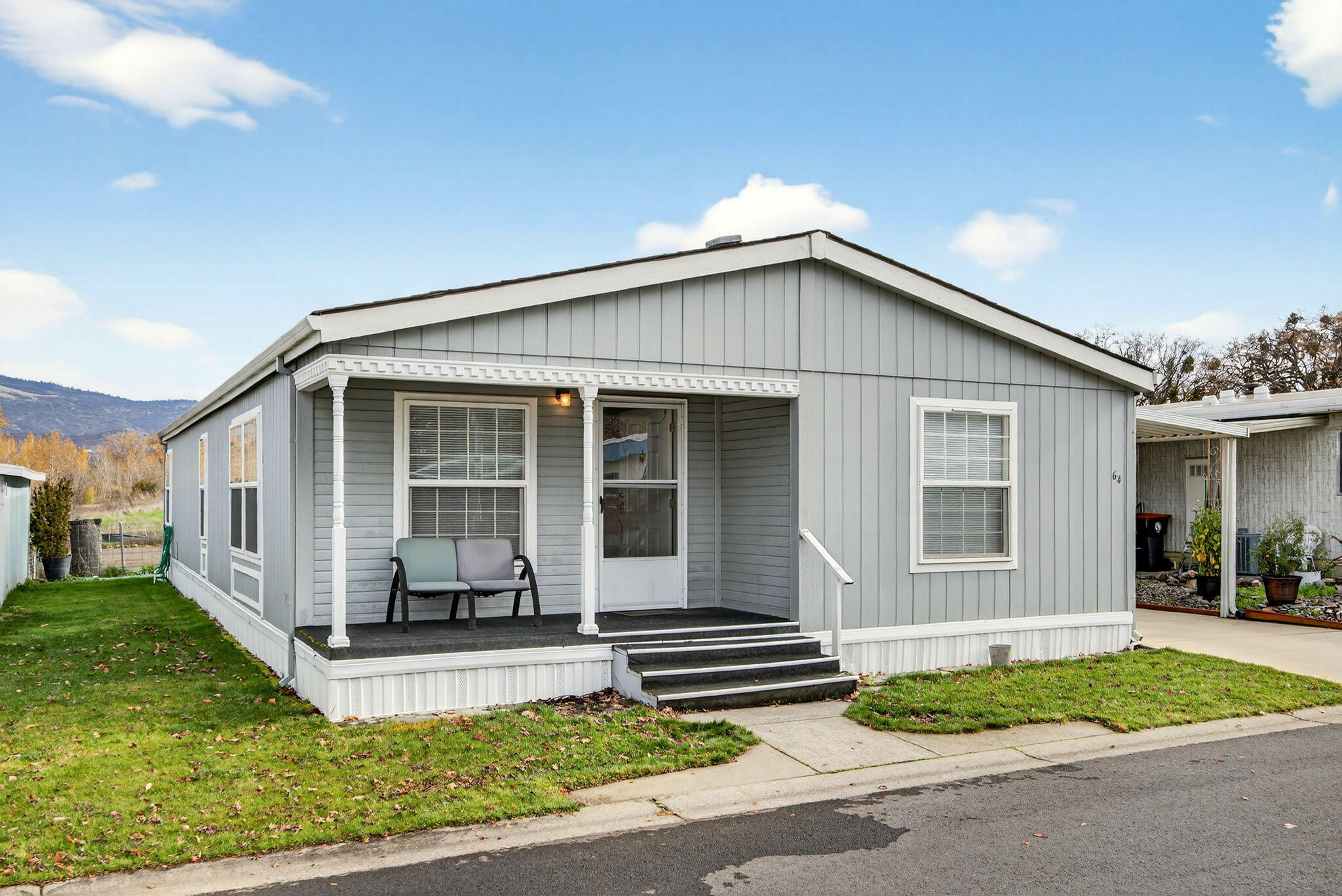Beautiful and well-maintained manufactured home in Glenwood Estates, a 55+ community. This move-in-ready home backs to a greenway with mountain views and offers quick access to walking trails and nearby shopping. Enjoy the charming front porch, mature landscaping, and a spacious side yard with two storage sheds. Inside, you'll find a new HVAC system, LVP flooring in the kitchen with tile countertops, great living room and lots of natural lighting. Kitchen offers abundant cabinetry, great counter space and appliances. Spacious primary bedroom with attached bathroom and a stylish tile walk-in shower. Warm, inviting, and thoughtfully cared for, this home is the perfect blend of convenience, beauty, and low-maintenance living in a welcoming community.