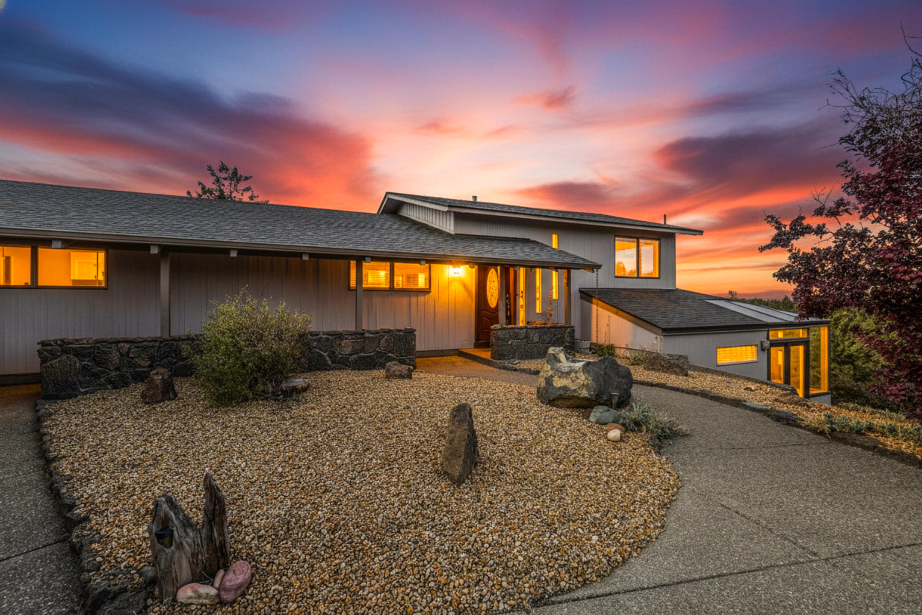 Enjoy main-level living at its best with panoramic views stretching from the Cascade Mountains to Smith Rock. Nestled on 2.74 acres, this home offers an open living area with a rock-surround fireplace and double sliding glass doors leading to a spacious deck overlooking the water feature and stunning mountain vistas. The main floor includes an open kitchen, dining area, second living space, office, and laundry room. Downstairs, a daylight basement provides a versatile studio-style suite with a full bath and bar area, perfect for guests or use as an ADU. Experience the tranquility, space, and breathtaking scenery that make this property truly exceptional.