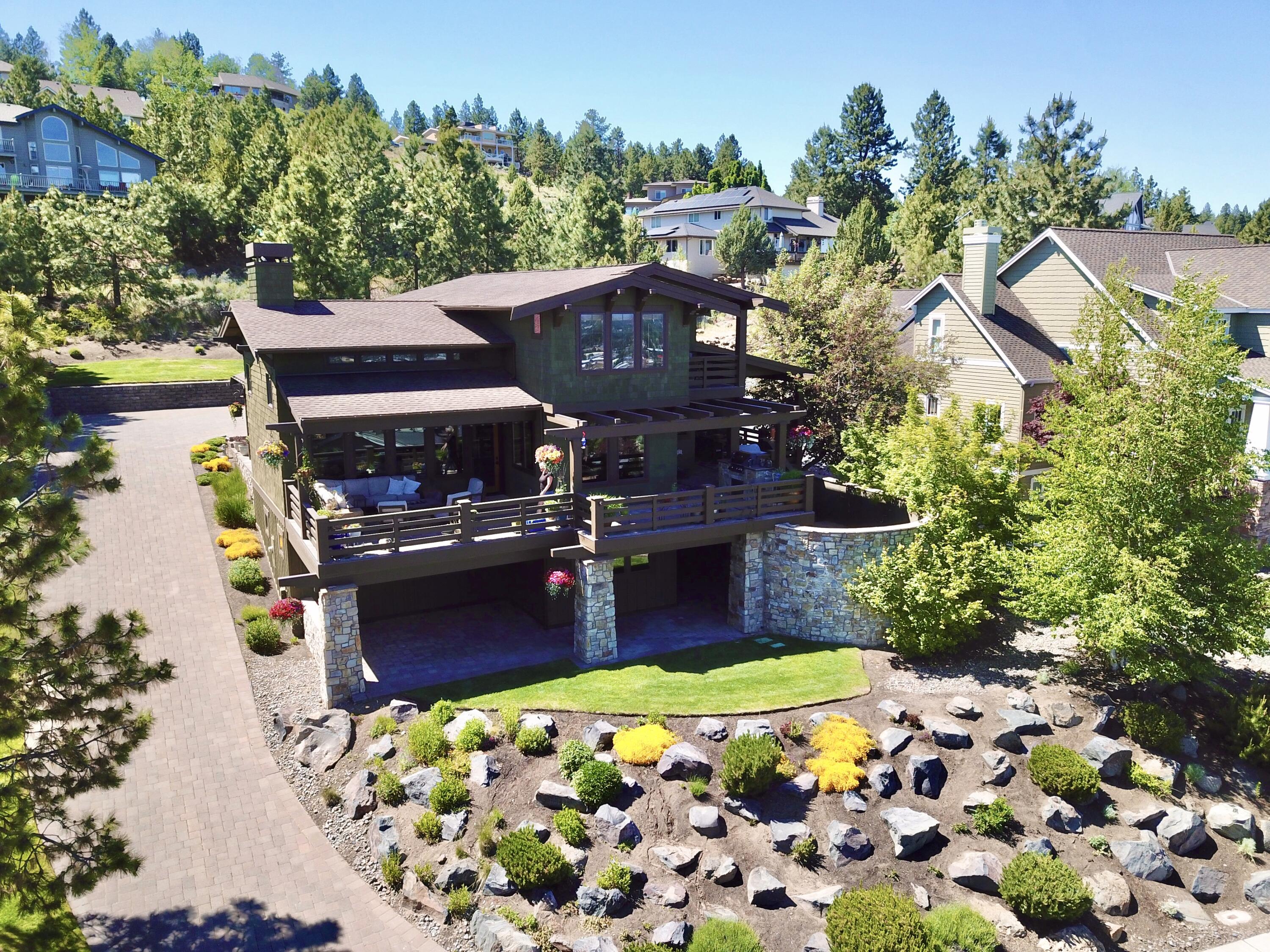 Welcome to your sanctuary atop Awbrey Heights! Revel in breathtaking easterly views from your secluded deck, perfect for peaceful mornings or hosting gatherings with a view of our 4th of July fireworks! Inside, a cozy gas fireplace and expansive vistas welcome you into this beautiful and spacious great room with high ceilings. Discover culinary delights in this chef's kitchen featuring sleek slab countertops, a generous center island, and top-of-the-line stainless steel appliances, including a double oven and 6-burner range, all perfect for entertaining friends and family. Other features include a wine and beverage fridge, walk-through pantry, and dedicated laundry room. The lavish main-level primary suite offers deck access. Upstairs, a generous secondary suite with views awaits. Downstairs, indulge in a two-bedroom bonus area with a gym and a double office. With copious storage options throughout and defensible space for added safety, embrace peace of mind in your custom retreat!