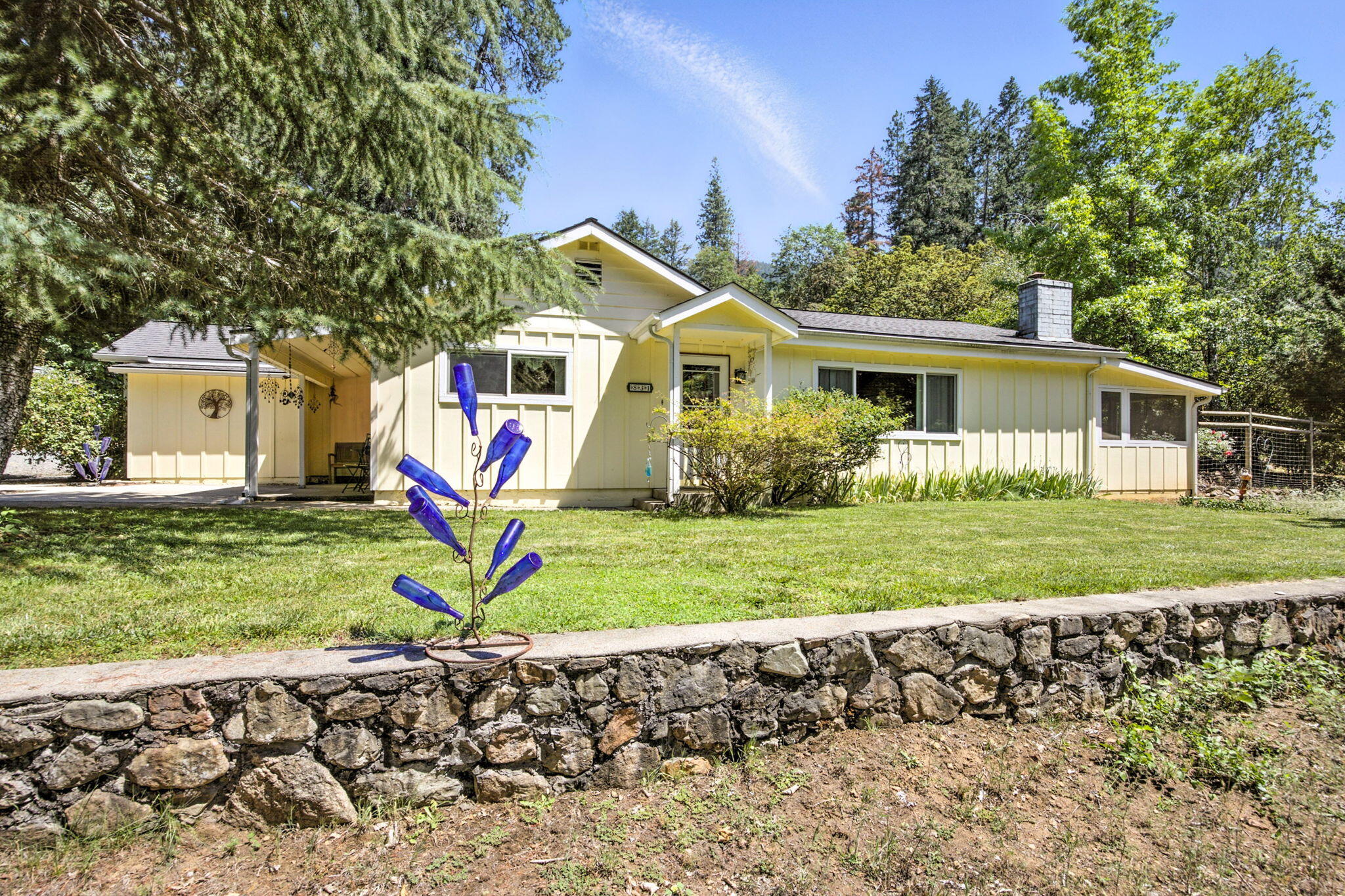 Homesteader's Dream situated on 1.68 semi-private acres featuring beautiful stone pathways, flowers, garden and pasture. The Ranch style home features many recent updates including LVP flooring, vinyl windows, HVAC system/ducting, 40 yr roof (2010), stainless steel appliances, pantry w/pull-outs & hot water heater. The tile entryway leads to a large built-in bookcase and open beam vaulted ceiling extending from the kitchen, dining area, to the cozy living room with brick fireplace & woodstove insert. Huge 10'x30' screened-in carpeted porch offers additional living area for yoga/gym equipment/artist retreat.  The 40'x25' detached garage is insulated & sheet-rocked with room for 2 cars + Motorcycle/ATV, shop, plus beautiful guest quarters studio w/kitchen & bath w/shower. Fenced & split rail cross-fenced, 12'x12' barn, large chicken coop, raised garden beds, 2-storage sheds, aerated composter, handcrafted rock work, terraced planters, sprinklers & RV parking w/power/water hook-ups!