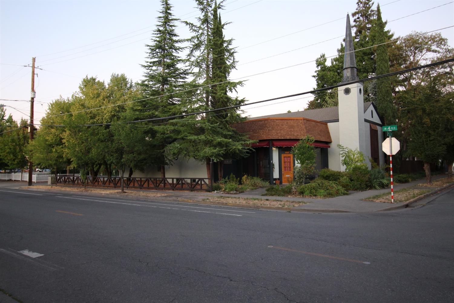 Endless possibilities with this unique property close to downtown Grants Pass. Built in 1945 and over 4300 s.f. It was originally built as a church. Quality of Construction of this building is evident when you see the original, flat, solid oak floors of the main room. Towering ceilings and windows, full kitchen, a raised stage for performances, open spaces and lots of potential. Currently used as a residence, this piece is zoned R4, with commercial potential. The lot is over sized (.34), fenced and protects one of GP's largest redwood tree and plenty of off street parking. Possible business, community center, school, church, studio, etc. Owner motivated, owner will finance. All information deemed reliable, but not guaranteed. Any potential Buyer encouraged to perform their due-diligence.