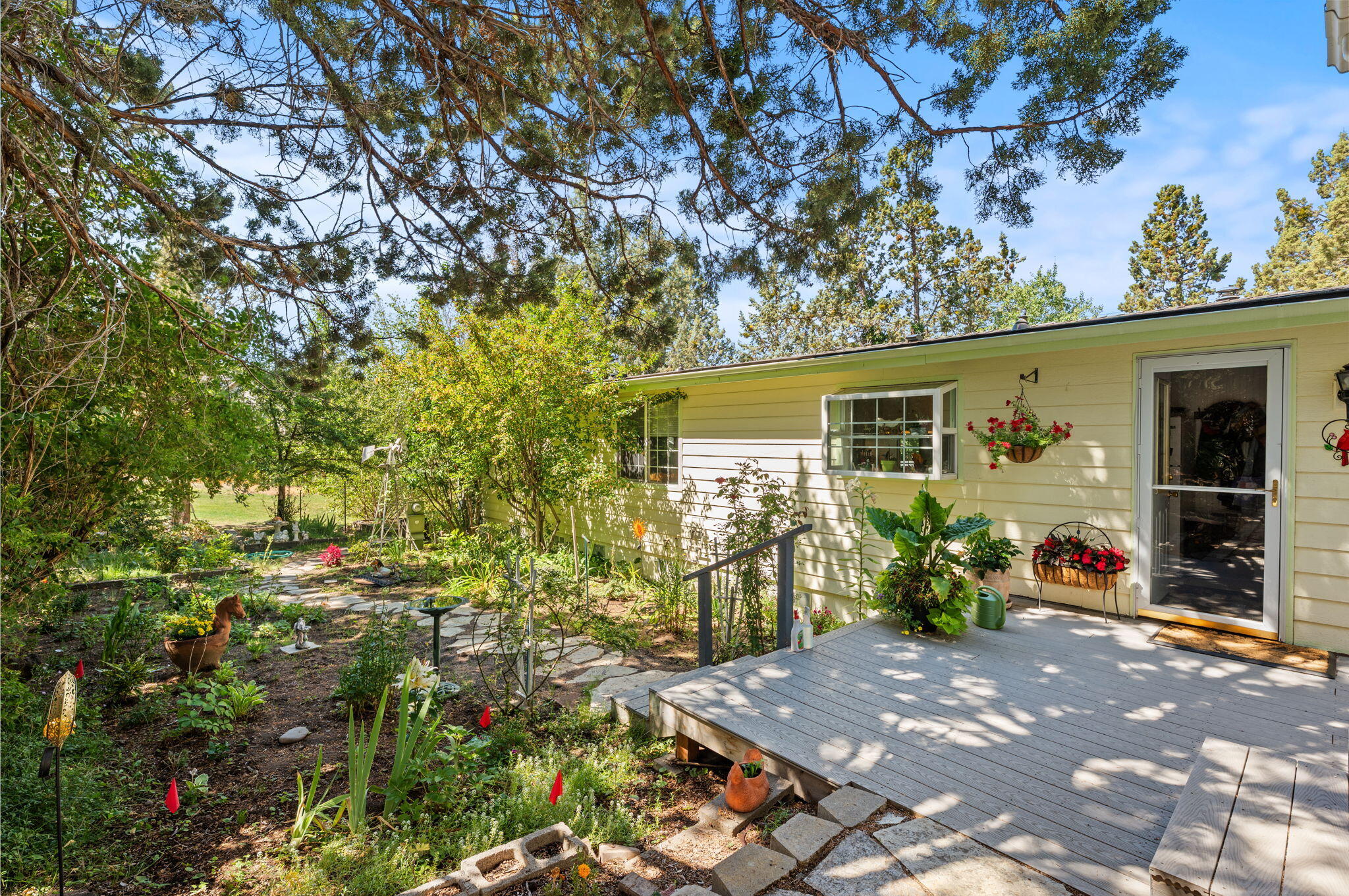 Nestled in the heart of Cascade Village, a sought-after 55+ community, this home offers a rare sense of calm and privacy. Located at the quiet end of a cul-de-sac and surrounded by mature trees, the setting feels peaceful and secluded from the moment you arrive. The layout offers great separation, with two guest bedrooms on one side of the home, a private primary suite on the other, and an open central living space anchored by a cozy pellet stove. Abundant windows and glass doors invite in natural light and create an easy indoor-outdoor feel. A spacious deck extends the living space outdoors, offering plenty of room for dining, entertaining, or relaxing while overlooking the lush lawn. Mature landscaping, a vibrant garden, and blooming rose bushes add beauty and warmth to the setting. A large shed provides flexible space to suit a variety of needs. Enjoy access to a pool, clubhouse, fitness center, and a full calendar of community events!
