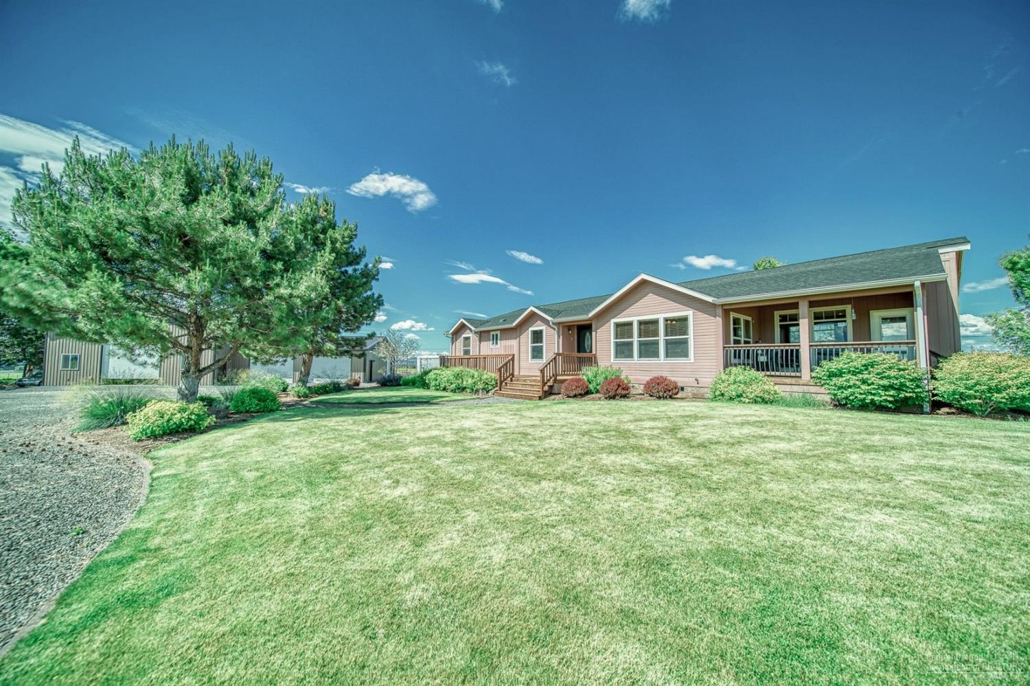 Immaculate Ranch on 128.49 acres with a full pivot, beautiful triple wide manufactured home with open great room, family room and 4 bedrooms/2 baths and large laundry room all with nice upgrades and stunning Cascade Views. Plenty of room for all of your equipment or toys with the huge fully finished shop with 2 reznor heaters and air compressor with attached finished garage.