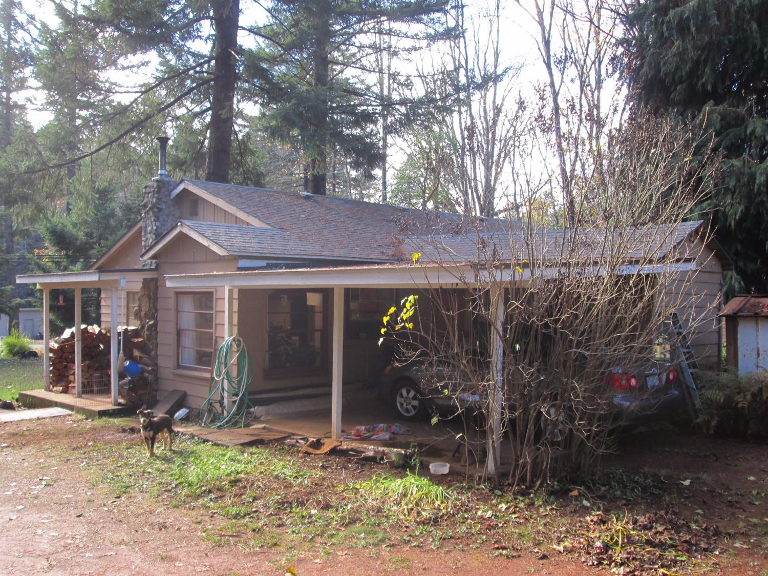 Don't let the size fool you. Great floor plan makes this cottage style home feel very spacious and comfortable. Featuring 2 bedrooms plus den (that could be a 3rd bedroom) and 1 bath home located on just over half an acre. The laundry/mud room located off the kitchen makes it easy to park and unload the groceries just before you step foot in the kitchen. The efficient woodstove heats the entire house. Newer septic system in 2010 and new plumbing in 2017 and new roof in 2016. With a few cosmetic updates, this home would shine. Beautiful level property with lots of trees and plenty of room for a large garden and RV parking. Close to city services and a short drive to Grants Pass.