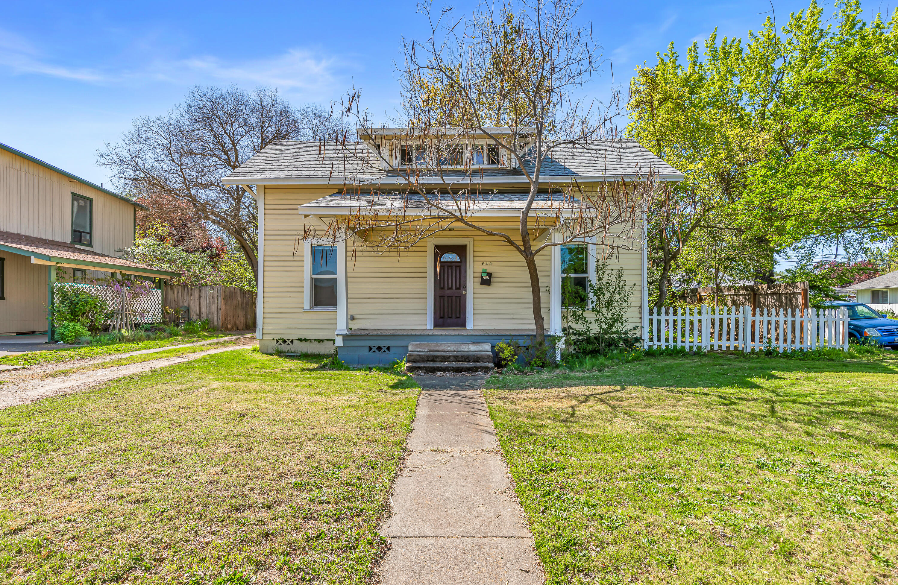 This charming three-bedroom, one-bathroom cottage offers a wonderful opportunity for investors or buyers looking to restore its original character. Filled with natural light, the home features an oversized living room with hardwood floors that flow into an adjoining dining area. The main-level primary bedroom and bathroom provide convenience, while two additional upstairs bedrooms offer flexible space for family or a home office. The kitchen features durable tile flooring and abundant cabinet space for all your storage needs. Situated on a spacious corner lot with mature landscaping, a fully fenced backyard and a detached single-car garage adds convenience and completes the property. This is an as-is sale.