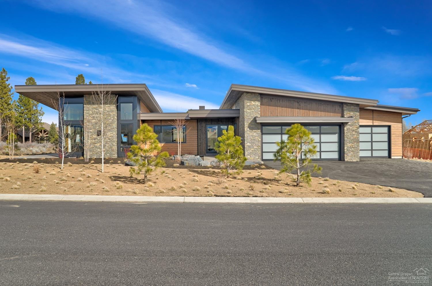 Designed by Design Haus and built by BendTrend Homes in Tetherow, this single-level modern home won't disappoint with 3 suites, a bonus/media room, den, and Cascade Mtn views. The great room with vaulted ceilings is flooded with natural light through floor to ceiling windows and 3-panel sliding patio doors. The plan flows through the dining area with built-in buffet to the gourmet kitchen, featuring cabinetry that combines warm wood with white quartz countertops with a Greystone quartz island showpiece, and a separate eating bar, all opening to a private courtyard which is buffered by common space. The private den and master suite are on one side of the home, providing nice separation. The master has courtyard access and the en-suite bath boasts a soaking tub, tiled shower, and dual-vanities with quartz counters. A 3-car garage and enviable mud room complete the package. Cascade Highlands Trail for biking & hiking out your front door. Walk-through virtually via attached 3DMatterport!