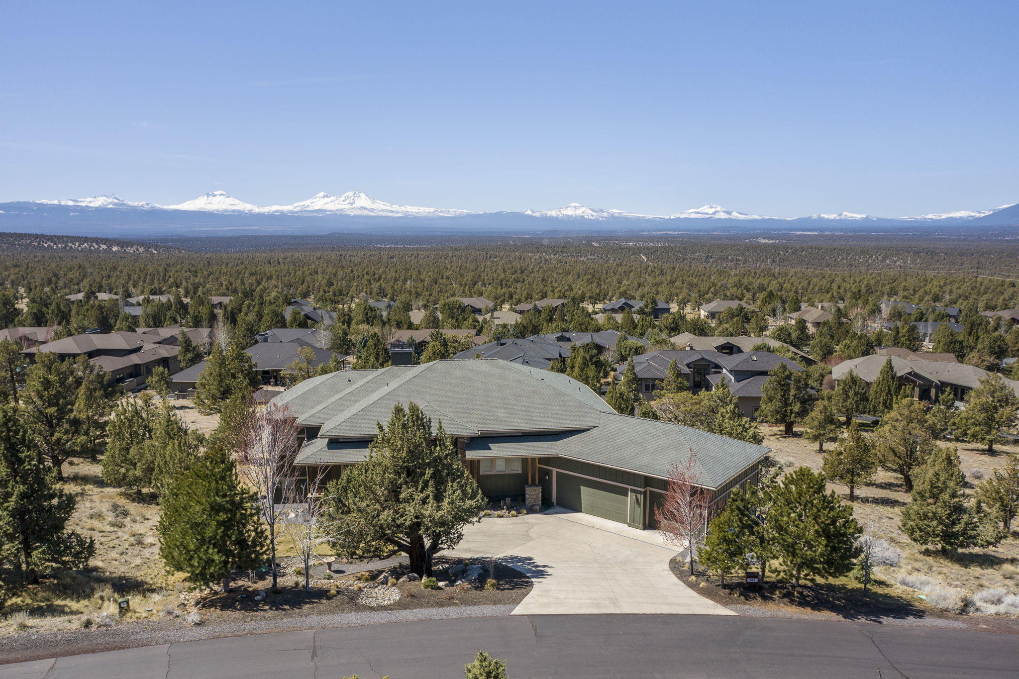 Must-see Cascade Mountain views from every back window of this beautiful home on top of hill in Ridge at Eagle Crest. Grand living room has custom gas fireplace w/wood mantel built-in. Large kitchen has ample storage w/island, tons of cabinets & counter space as well as sit-down dining area in addition to formal dining room. Spacious downstairs bedrooms w/views as well as separate office & large flex space w/built-in counter. Master suite has fireplace access to deck, walk-in closet & ensuite w/jetted soaking tub & large walk-in shower. Home also has central vac, heat pump & custom tile floors in kitchen, bathrooms & laundry room, which has a sink & cabinets. Outside are huge composite decks in both front & back & landscaped backyard w/sitting area & water feature. There's also an oversized finished triple car garage & huge storage/mechanical area under first level of home. Enjoy all the Eagle Crest amenities – 3 golf course, 3 sport centers, paved hiking trails & much more!