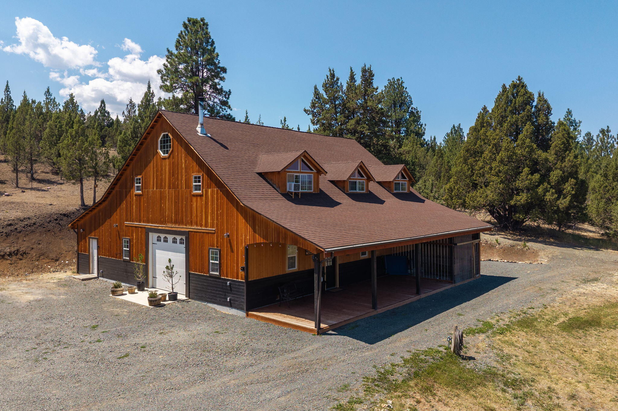 This impressive Contemporary home features four bedrooms and two bathrooms, encompassing a total of 3,456 square feet and constructed in 2008. The main floor boasts acid-stained concrete floors, a spacious family room that could easily be converted back into shop space if desired, two non-conforming bedrooms, a bathroom equipped with a washer and dryer, an office area, and ample storage. The home is heated with woodstove and wall heaters.
The upper level includes two additional bedrooms, a bathroom, a living room, a dining area, a kitchen, and a second office space. The property is situated on 7.77 fenced acres, offering privacy and scenic views, and includes a large covered deck. Additionally, there is an unfinished shop with a concrete floor, providing further potential for customization.