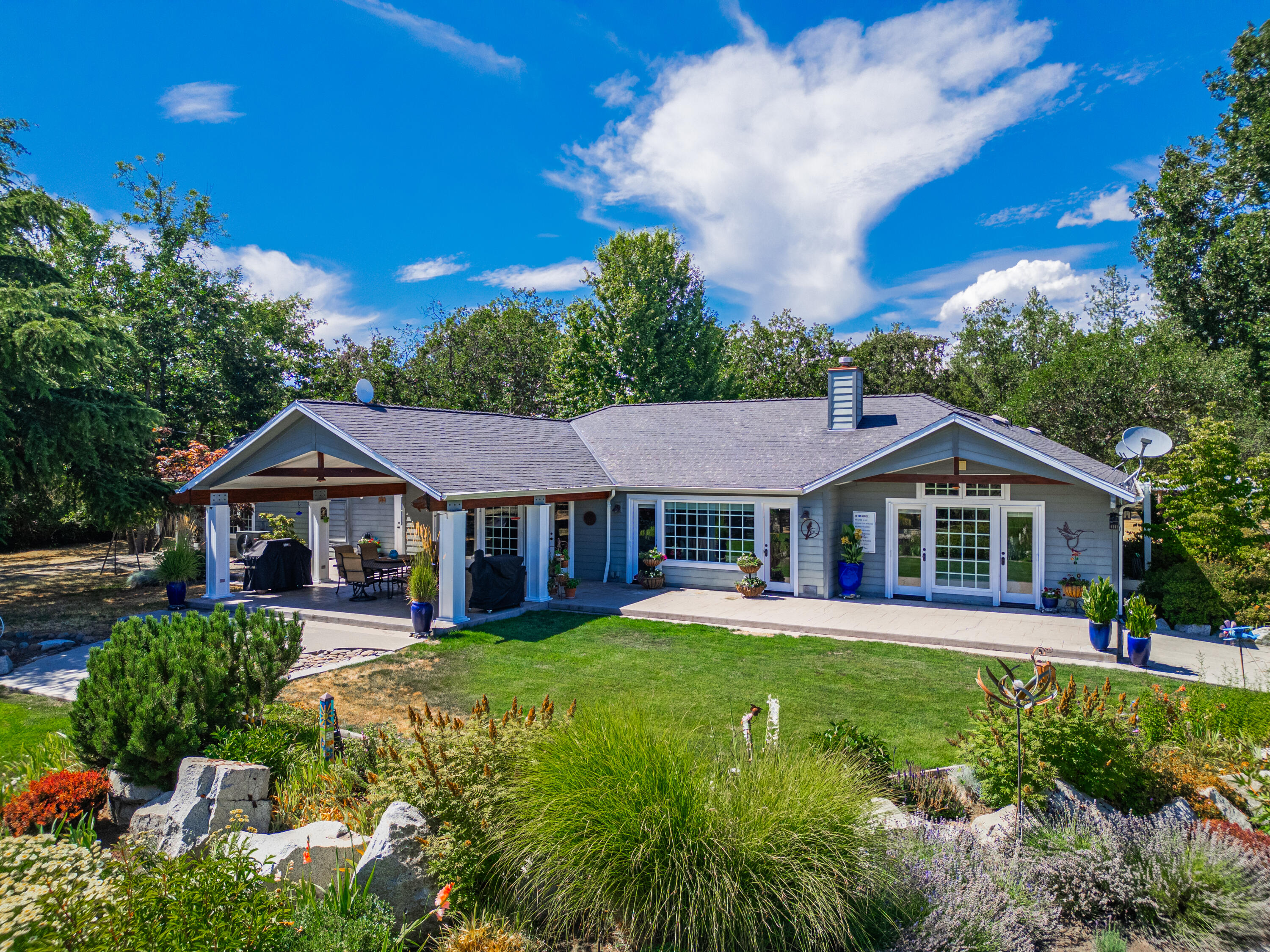 Welcome to your private riverfront retreat! This stunning single-level estate sits on 8+ manicured acres with around 300 ft of low-bank frontage along the scenic Rogue River Run area of the Rogue River. Parcel has partial fencing and large paddocks.  It offers privacy and space for gardens, hobbies, RVs & more. Enjoy the scenery from the covered patio overlooking lush grounds. Follow a private path to your serene riverfront, complete with a custom treehouse with zipline. There is peaceful  river seating area, perfect for morning coffee or sunset views. Inside, the home features a spacious primary suite with a luxurious bath, walk-in closet & private office. The gourmet kitchen offers generous counter space, premium finishes & garden views. A separate wing provides additional bedrooms and baths for guests or family. Multiple outbuildings offer ample storage and space for all your needs. A rare opportunity to enjoy comfort, elegance & natural beauty in the heart of Rogue River living.