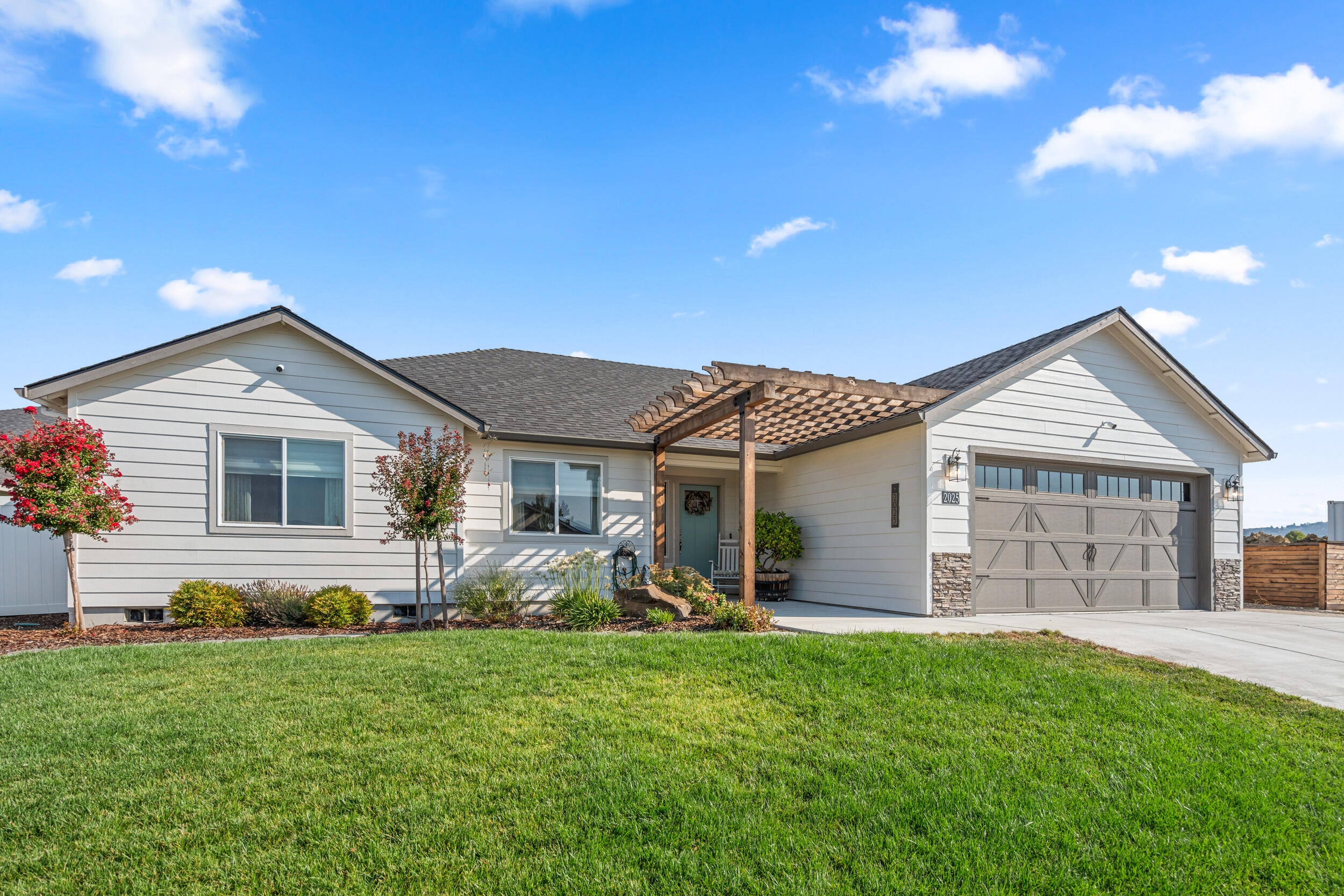 Custom crafted 3BD/2.5BA home in desirable E. Medford location. With thoughtful interior and exterior upgrades, and lovingly maintained by a single owner, this house shows better than new! You will be greeted by an open concept floor plan which features LVP flooring and vaulted ceilings. The kitchen is spacious and comes with quartz countertops, soft close cabinets, pull out drawers and a lazy susan in the lower cabinets. Both bathrooms are spacious and have custom tiled showers and matching quartz counters. The primary bath has dual vanities. The second bedroom has an attached bath with an extra-large closet making it perfect for guests or multigenerational living. The third bedroom features stunning mountain views and works great as an office space. Outside you'll find extensive upgraded landscaping including custom pergolas, two large sheds and a gas stub for your barbeque.