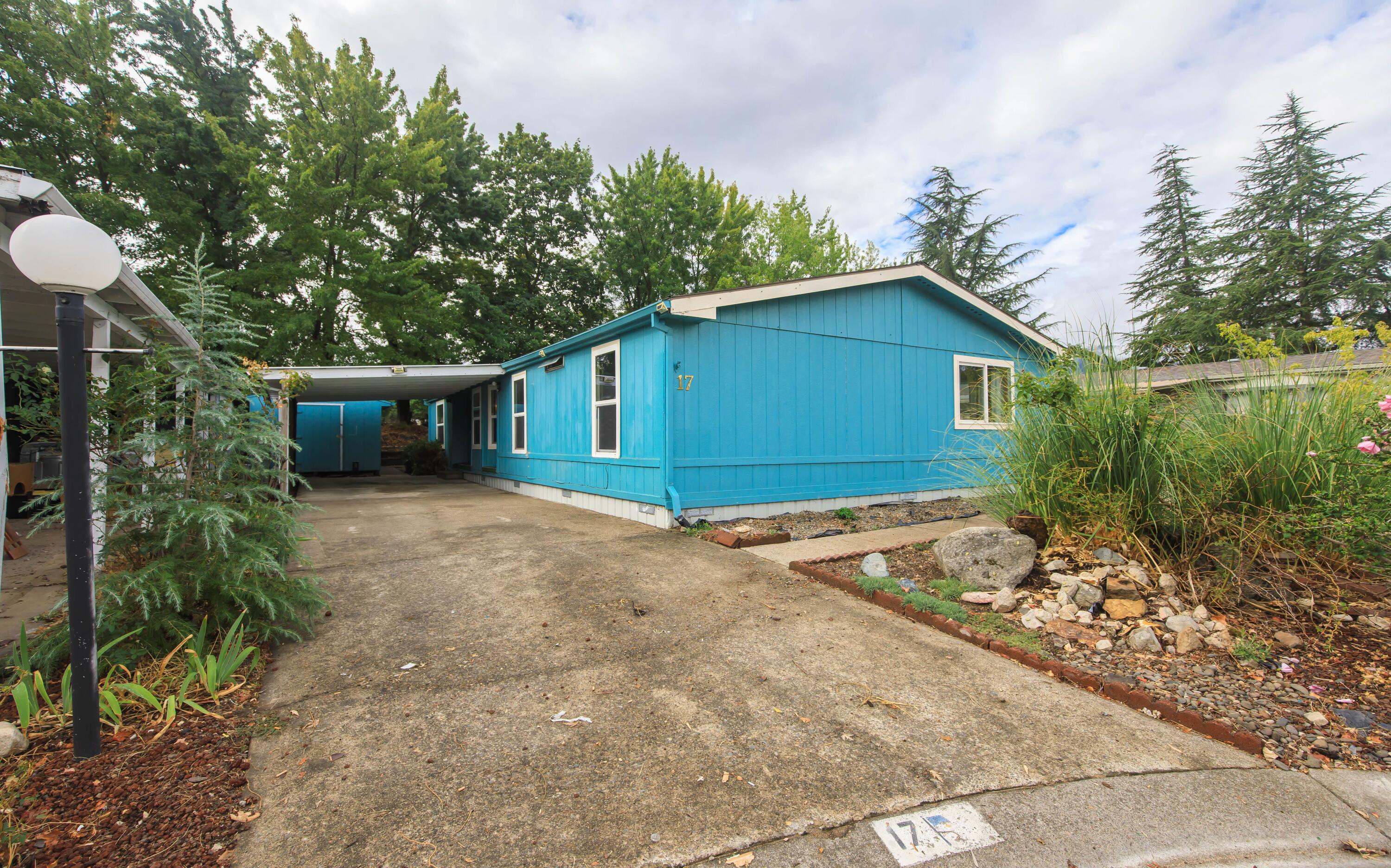 This 3 bedroom 2 bath home in Ashland's Tolman Creek all age park it backs up the  YMCA soccer fields. Convenient location  close to shopping, Dining , bus stop, YMCA and freeway exit. Open floor plan, w/vaulted ceilings and Skylights.  There's a good amount of living area with a family room and a living room. The dining room and laundry room are off the kitchen. Two bedrooms and guest bath on one side, primary on the other side. Primary has a walk-in closet and en-suite with walk-in shower. Covered carport, 2 storage sheds, terraced back yard and covered patio. This home is a diamond in the rough waiting for someone to make it shine.
