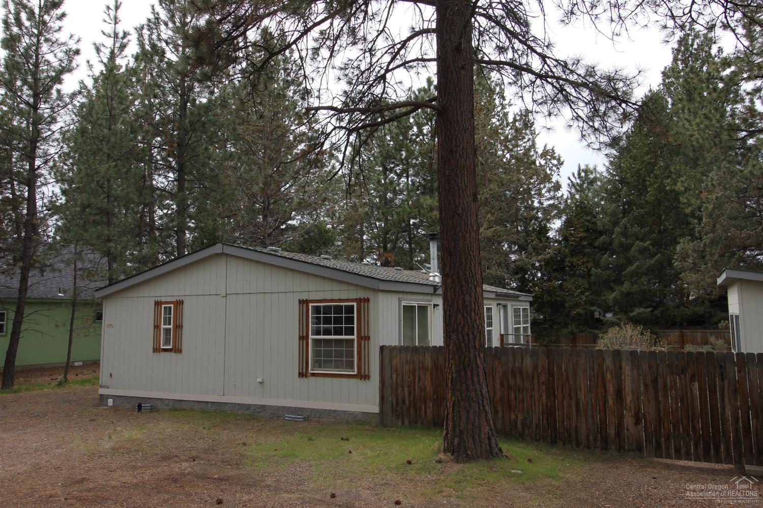 Clean well-sited manufactured home on a gorgeous lot with mature Ponderosa Pines! Newer roof, nicely fenced back yard, and plenty of room to park! Open floor plan with vaulted great room. Separation of the master bedroom and two additional bedrooms is a very nice touch.