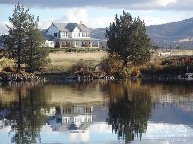 In desirable Powell Butte community on 98 ac, 64 irrigated, is a beautiful 4 bedroom, 2.75 bath, 2848 sq ft home with a wrap around porch, oversized 2 car garage, shop & hay barn with lean-to. This property is fenced and cross fenced. Bring your fishing poles, included is a portion of a beautiful lake with well developed fishing habitat for outstanding bass fishing (5 & 6 lb lunkers), 2 irrigation ponds, great for goose hunting. The waterfowl population is tremendous. Watch them land on the lake every night. Bring your .22 for great rockchuck and sage rat hunting. Enjoy the large deer population that roams through. This property is down a long lane with country quietness and peaceful surroundings. There are outstanding views of 8 Cascade Mtn. peaks, Smith Rock, and Ochoco Mtns. Enjoy coffee on the porch and watch the sun rise over the Ochocos or at the close of a day, the sun setting over the lake and the gorgeous Cascades. Come ranch, fish, hunt, ride and enjoy life in Powell