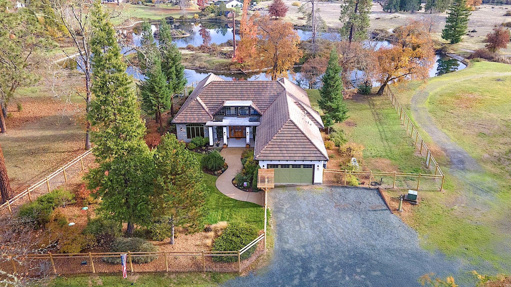Discover this truly one-of-a-kind home on Deer Lake in the Paradise Ranch community. Designed by John Magallon, this stunning 3,039 sq. ft. residence showcases vaulted ceilings with wood-encased beams, rich hardwood floors, a tile entry, gas fireplace and expansive windows and French doors that fill the space with natural light. The gourmet kitchen is a chef's dream, featuring granite countertops, knotty alder cabinetry, a 6-burner stove, custom fixtures, and a spacious island and pantry. The primary suite offers a luxurious retreat with a walk-in shower, bidet, and huge closet. Step outside to your own private haven complete with an amazing outdoor kitchen, fenced garden, and beautifully landscaped grounds. Enjoy fishing, walking trails, and the abundant wildlife that make this setting so special. This exceptional property is one you won't want to miss!