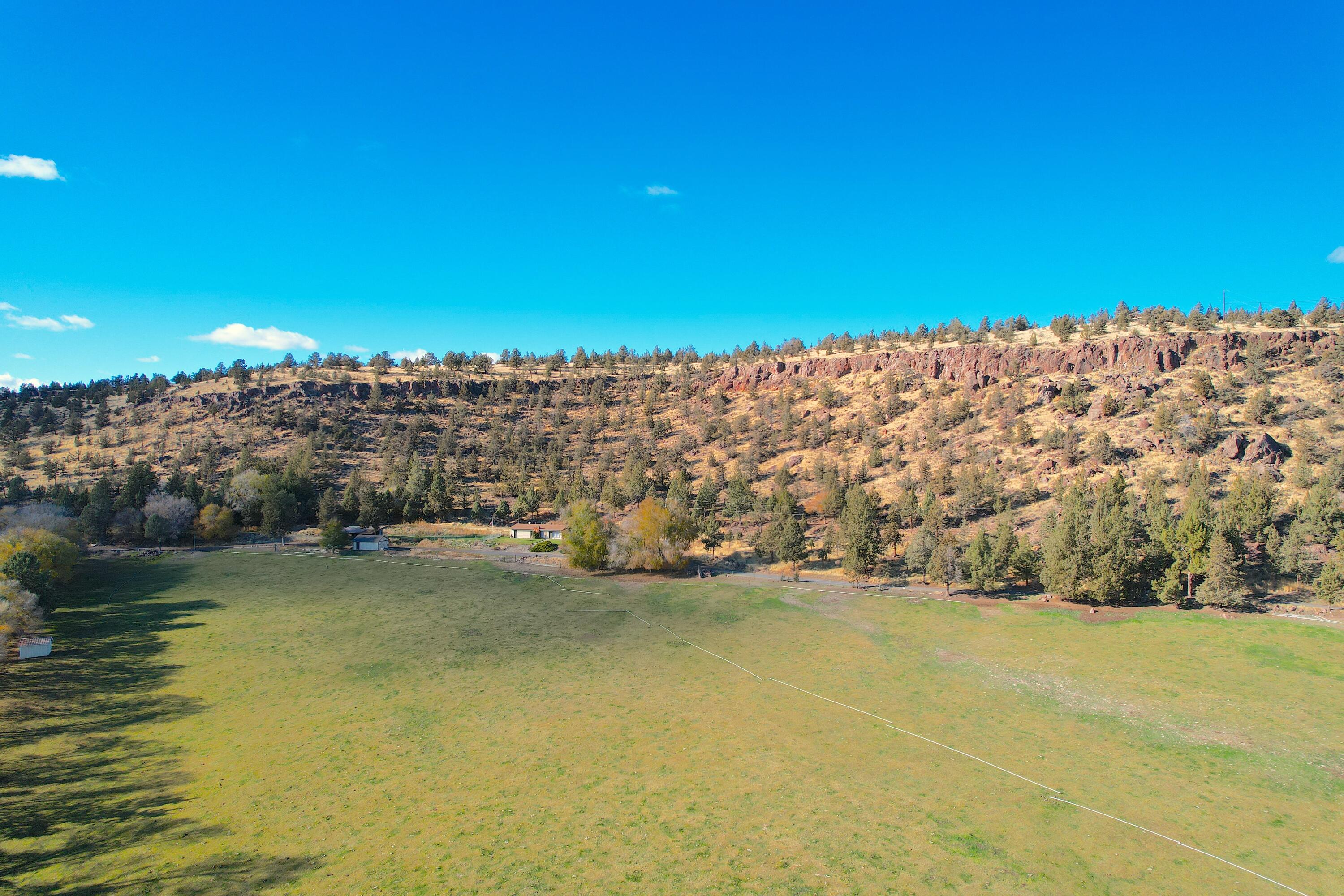 27 acres on the edge of town with huge development potential. This property has an SR1 zoning, sits next to Prineville city limits boundary, and city water and sewer lines have been brought to the property line! The existing 1600 sqft home has been updated with newer flooring and kitchen cabinets and counters! There are two manufactured homes on the property being used as rentals and an additional 2 full RV hookups. The property has 10 acres of irrigation water rights and is fully fenced. Call your favorite agent to discuss the many possible uses of this land!