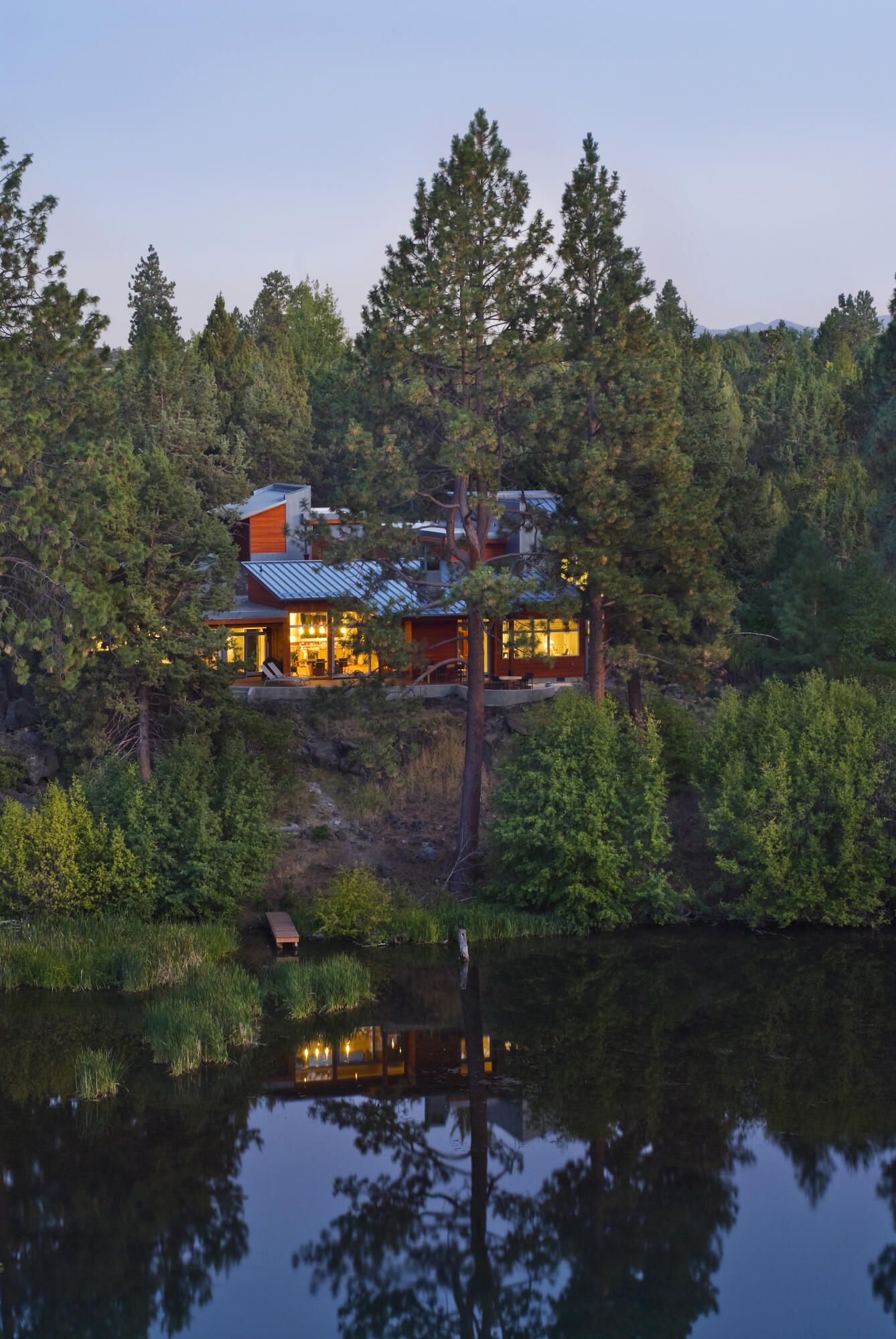 Take in breathtaking views from this extraordinary modern masterpiece perched above the river & a short distance from Downtown Bend. Enter through a lavish courtyard filled w/ native plants & stunning architectural style. A passive-solar design & towering windows fill the great room w/ light & captivating views that invite the outdoors in. A luxurious suite awaits in the North wing complete w/ 2 customized bathrooms, 2 walk-in closets, & gym. The South wing boasts 2 river view ensuites, & an office w/ phenomenal views. Take in nature from the expansive deck w/ multiple settings for entertainment & relaxation. Paddleboard on the river from the dock.  Meticulously maintained by the original owners, this home is perfectly appointed for a comfortable Central Oregon lifestyle. Some of the many features include Brazilian mahogany floors, 12-zone radiant floor heat, premium appliances, remote shades & windows, wine fridge, dumb waiter & greenhouse. A list of amenities available upon request!