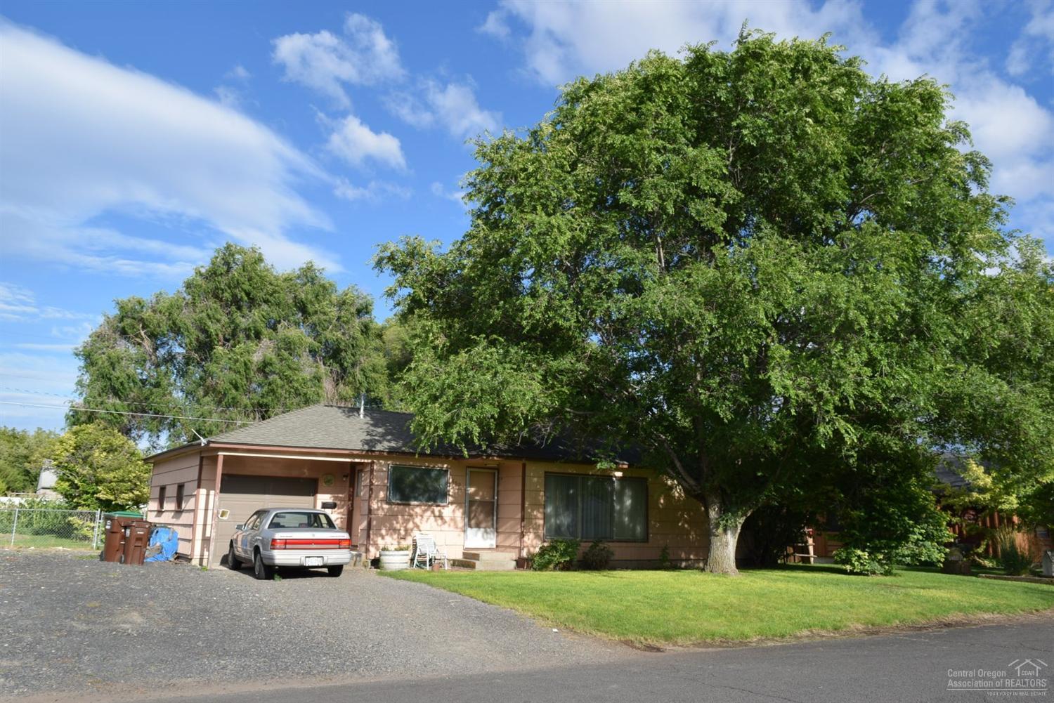 Vintage Charm with nice floor plan, cedar sided cottage surrounded by luscious green grass via sprinkler system used from private well. 2 bed, 1 bath, 992 sq ft per Assessors Office, natural gas wall furnace and hot water. Garage with workbench and electric door opener. Roof was replaced about 5 years ago per Seller. Two gardens have produced amazing produce. Great shade tree.