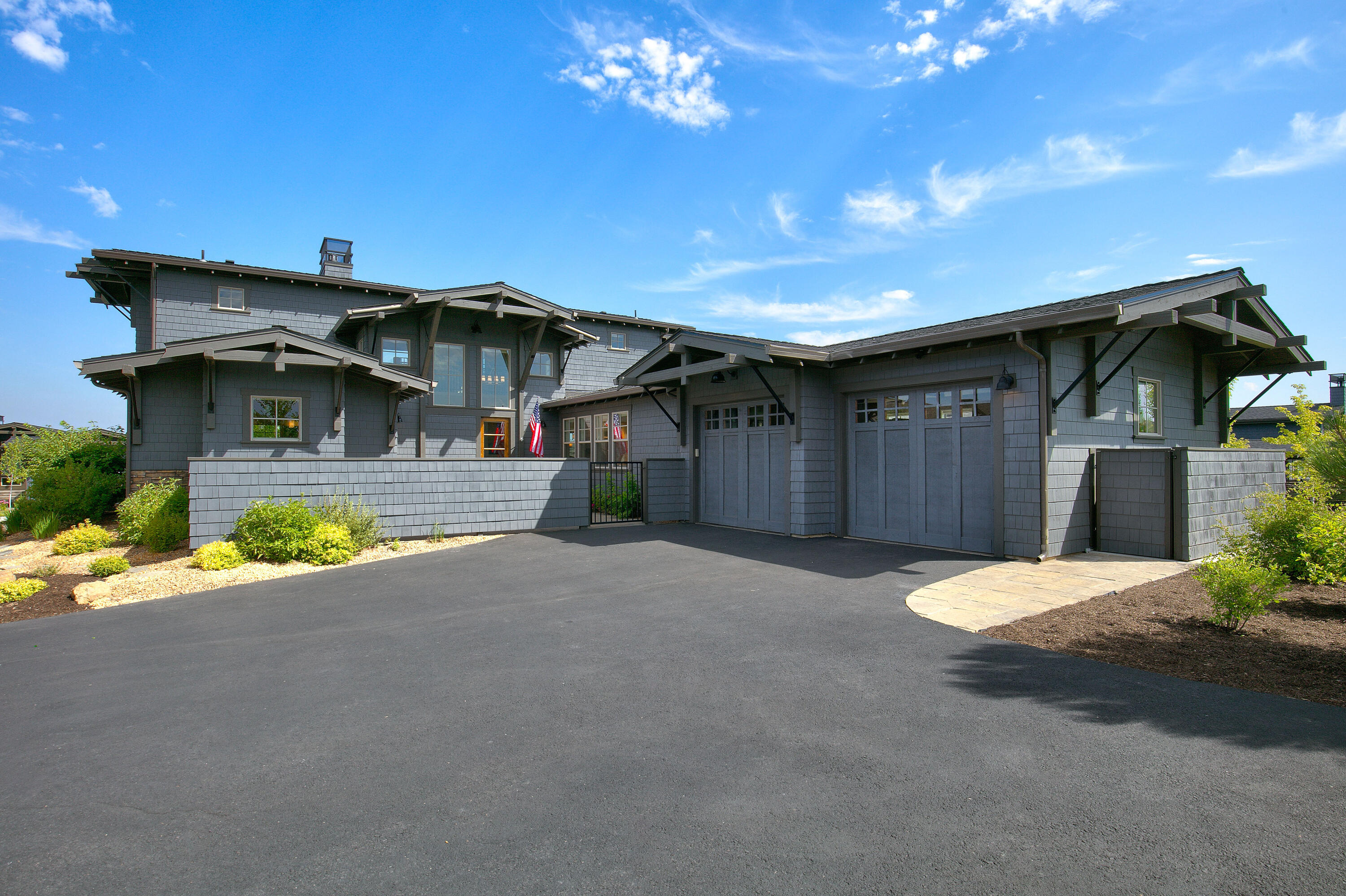 Discover the allure of this unique NW Contemporary home with an open floor plan and a luxurious main-level primary suite. The light-filled great room impresses with soaring ceilings and mountain views, a stone fireplace, and beautiful hardwood floors. A chef's kitchen features a granite island, quartz counters, Thermador appliances, and a large walk-in pantry. Step outside to the paver patio accessible from the dining area and primary suite, offering stunning Cascade and golf course views. Upstairs, two en-suite guest rooms connect via a sky bridge, each w/a private balcony to take in the mountains and golf course. The gated front courtyard offers a seating area and hot tub. Situated on a spacious corner lot in The Rim neighborhood of Tetherow. Attached 2 Car Garage. Enjoy easy access to community amenities, Phil's Trail network, Deschutes River, and Mt Bachelor road. A perfect blend of modern elegance and nature's splendor awaits in this remarkable home.