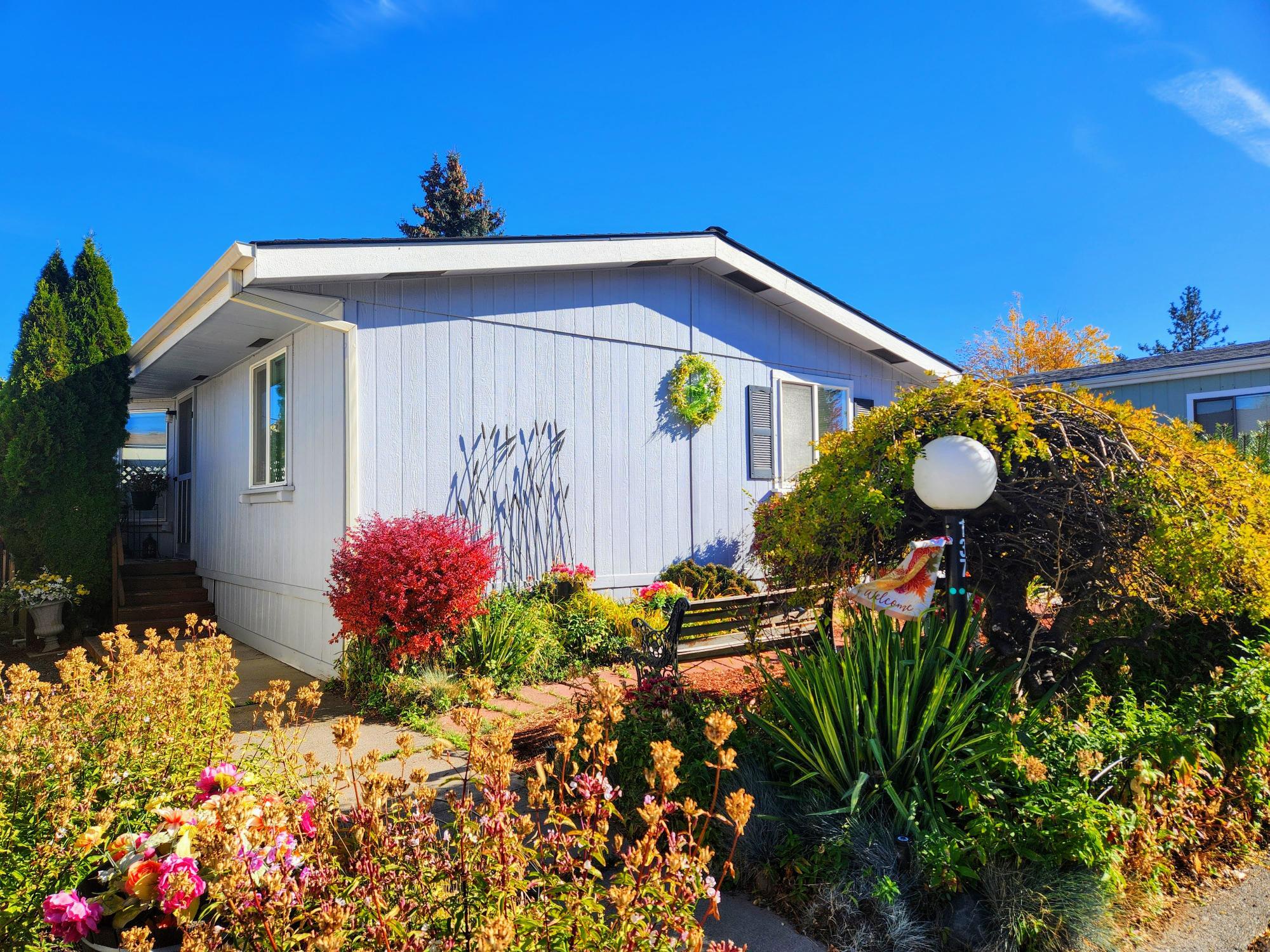 Welcome home to Suntree Village, one of Bend's finest 55+ parks. This home is move in ready, it's light and bright with vaulted ceilings, has a spacious living room with a big bay window, beautiful kitchen with lots of cabinets, beautiful counters and backsplash, kitchen island w/dishwasher and sink and large windows, a large primary suite w/lots of counter space and cabinets including a laundry bin, selves and lg stall shower, and good separation from the other rooms. Also, newer roof, heat pump and a Carport with storage unit and side and backyard. All in walking distance to The Larkspur Community Center where you can swim and exercise. Space Rent is $599.00 mo. includes water/sewer, trash, and use of the Clubhouse. Make an appointment to view today!