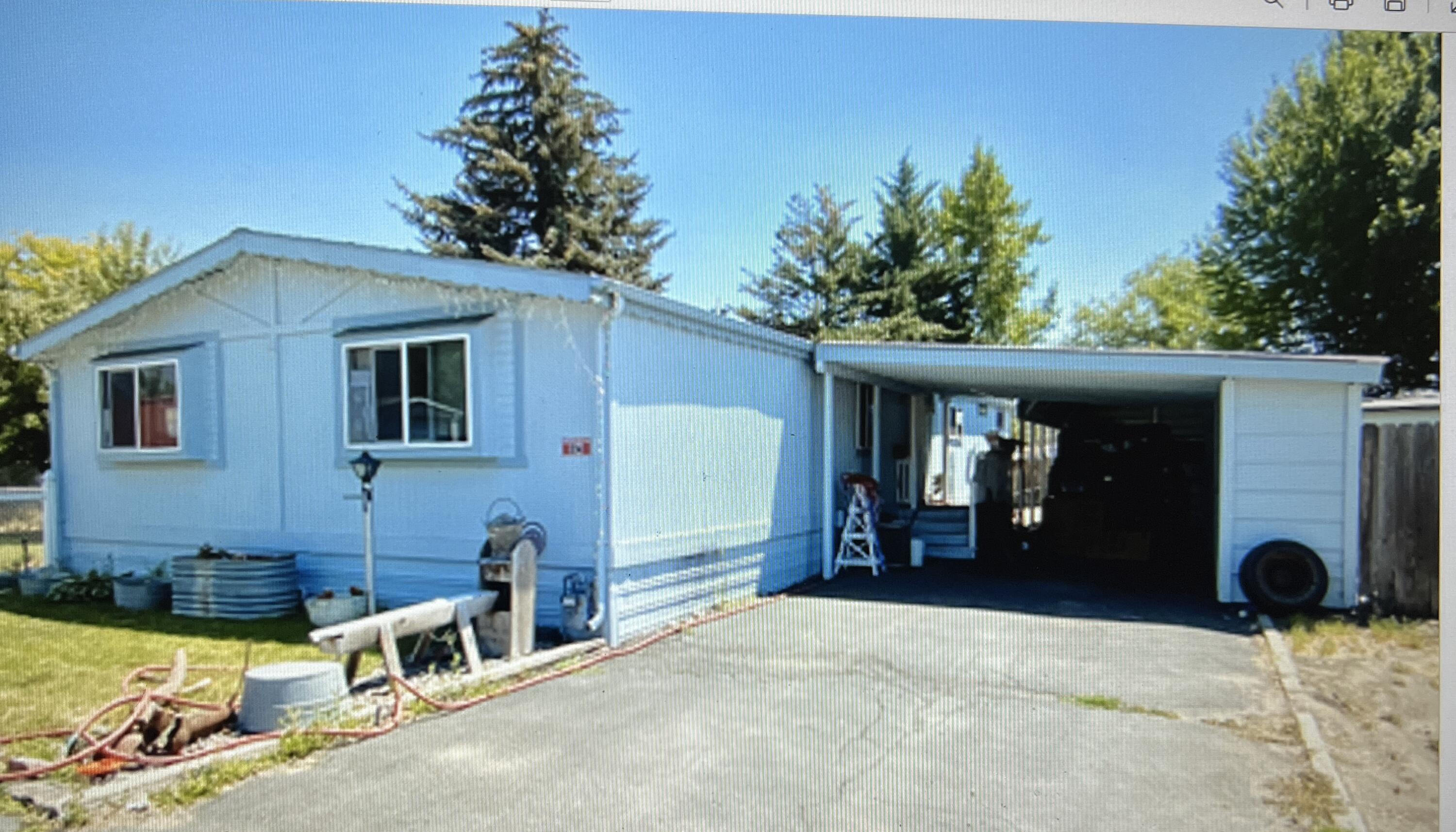 This large manufactured home in the Crest Street Mobile Home Park is at the end of the street with a large fenced yard, covered patio porch, storage sheds, and double length carport with storage cabinets. Living area is spacious, bedrooms are good size, and there is a large laundry room.