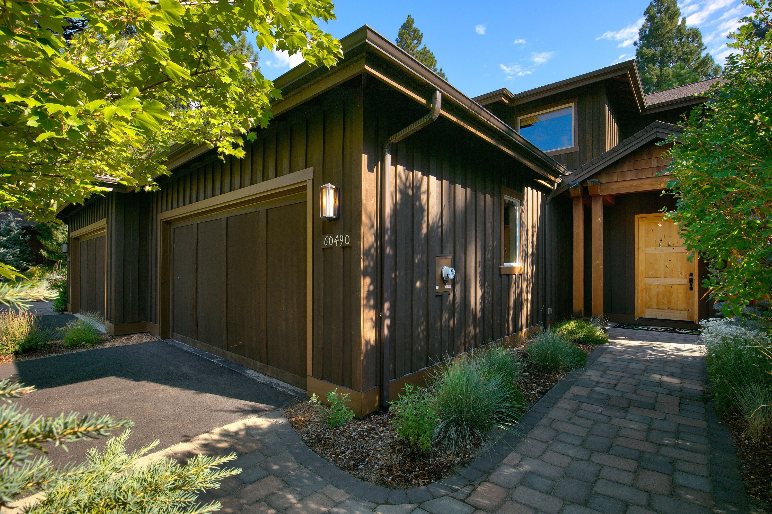 60490 Snap Shot Loop sits on one of the largest lots in the highly sought-after Points West Community. This luxurious townhome offers 4 beds, 3 & 1/2 baths with the primary master suite on the main floor. Designer selected finishes include custom built-in cabinetry, bar area with fridge, gourmet kitchen with an oversized quartz island, wood flooring and tile upgrades throughout the home. Upstairs, you will find 3 oversize bedrooms, (1 suite, 2 w/ Jack & Jill bath) for comfortable living. The large 2-car garage has epoxy flooring, a 50-amp 220 EV setup, and plenty of room for all your summer-to-winter toys and hobbies. The private covered patio has been professionally designed with pavers, a massive fire pit and a hot tub tastefully hidden in the trees of the manicured backyard. This Points West townhome is conveniently located minutes from downtown Bend and remains one of the closest residential areas to Mt. Bachelor and the Cascade Mountains. Don't miss out on this rare opportunity.