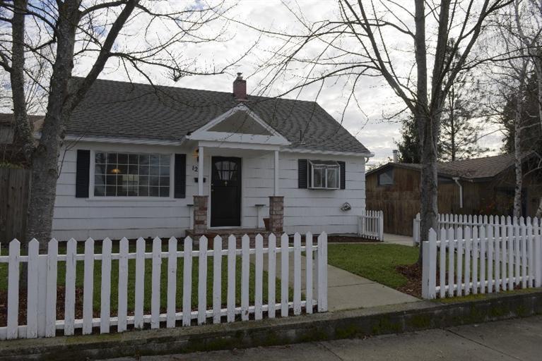 Cute older East Medford charmer with white cedar shakes, black shutters, covered front porch with brick columns, white picked fence in front yard with new lawn in front & back with large fenced backyard with alley access to RV parking or 3 cars. Many new updates from all new carpet, new range w/ glass cook top, newer heat pump, & new exterior paint & new interior paint. Main home that is 1212 sq ft w/great den/office off master suite upstairs, plus studio that has a wall A/C & heater built in Studio with lg walk in closet and good size laundry room with large sink and hobby area in laundry room. 3rd bedroom or great hobby room in detached studio . Zoning is MFR-20 for multi family. Studio was used for many years as a business called CruiseOne. Listing agent is a seller & related to co-seller.