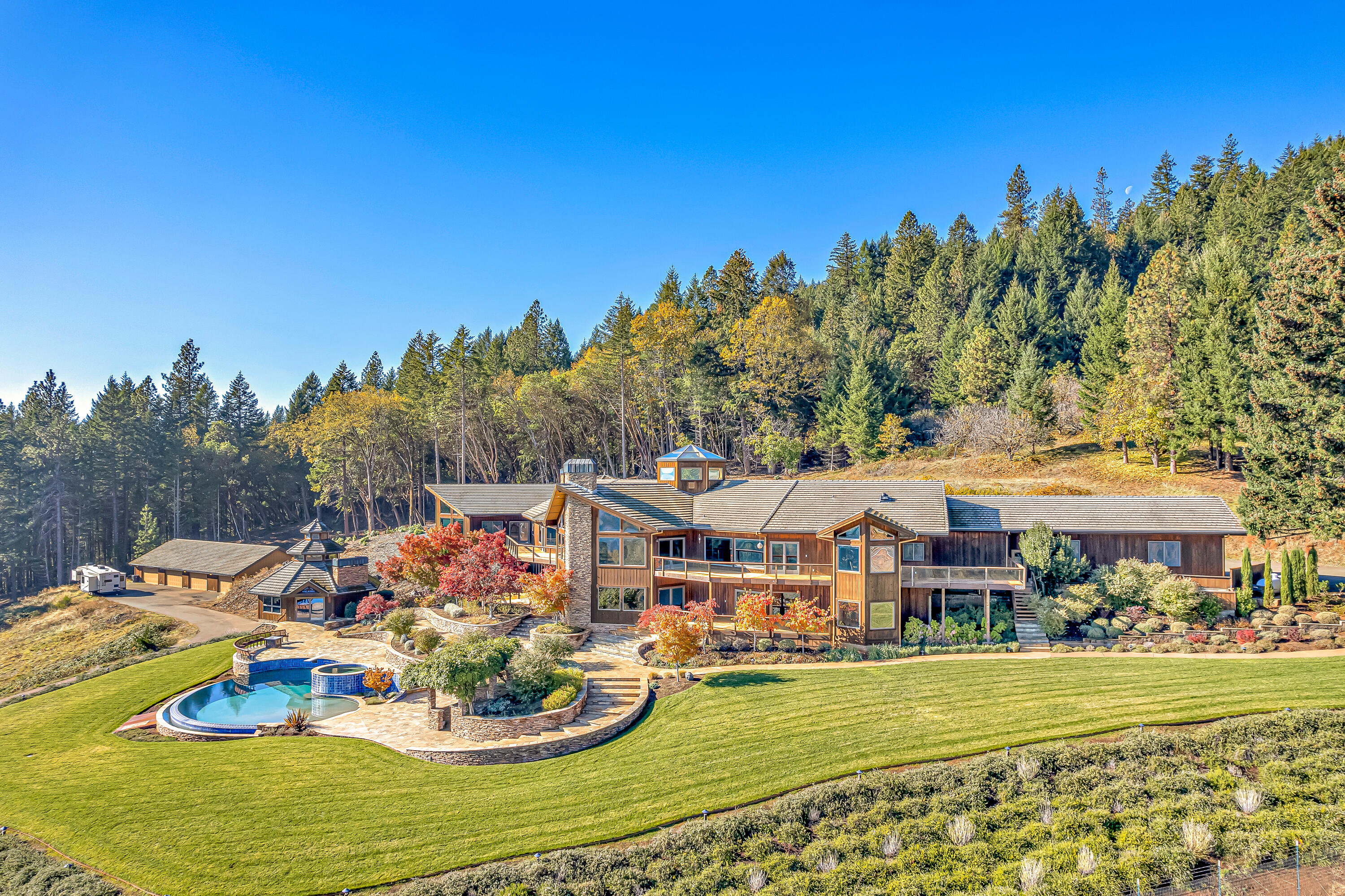 Welcome to Sky Ranch, a 12,000'+ multi-family estate on 83 acres, nestled in the beautiful Cascade Mountains of Southern Oregon. Back on market at no fault of property. The sweeping private drive reveals the formidable 10,199' mountain lodge, custom-built by Robert Repine, the original 1920's farm/guesthouse (approx. 2,500'), and the 3,600' detached shop/garage.  Inside the main home, you are welcomed by a Giant Bird of Paradise plant that the home is built around. On the main level, you will find a spacious living room with a bar, two built-in dens, a chef's kitchen, and the 2,300'+. primary suite complete with an en-suite office, two bathrooms, and a sauna. Downstairs, there are 3 additional bedrooms, a recreation room, and movie theatre. Stepping outside, there are extensive stone walkways surrounded by professional landscaping that will take you down to the pool, hot tub, and large poolside bar, with two full bathrooms/locker rooms below. Please find extended remarks attached.