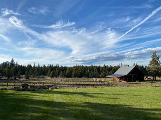 Welcome to serene country living with direct access to 160 acres of public lands and less than two miles to the thriving town of Sisters, Oregon. Relax on 9.6 private acres with clear views of Mt. Jefferson & Black Butte and over three hundred days of sunny skies. Appreciate the pastoral and forest landscape while you lounge by the pond with a dock, waterfall, sand beach, and firepit. Livable and spacious, yet simple to maintain, this 3,998 Total SF Pacific Northwest Craftsman has 4 bedrooms and 2.5 baths in the main residence plus an additional detached office/ studio with a kitchenette, full bath, and private entrance. Let your horses and pets run and graze in the fully fenced property, outdoor arena, and paddocks. The 2-stall barn has a center aisle, hayloft, and insulated 250 +/- SF tack room/workshop. Ample parking for vehicles, farm equipment, and recreational toys. Conveniently located within 30 minutes of Bend and the Redmond Airport. Enjoy Central Oregon living at its finest!