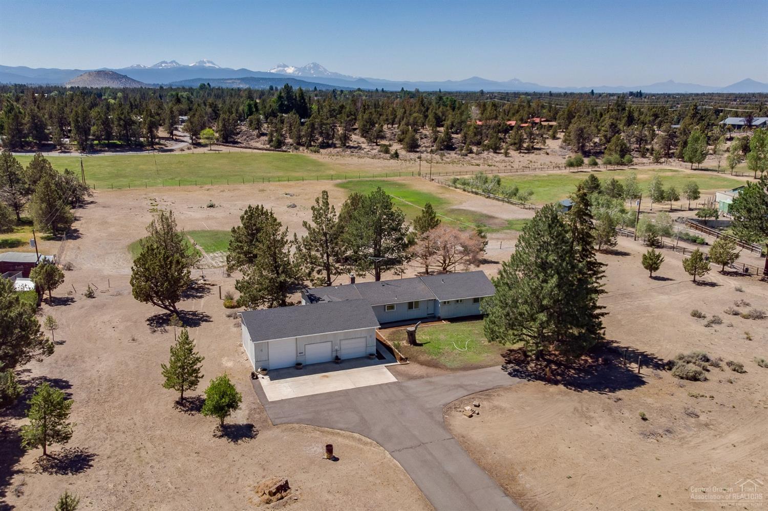 Wonderful country setting just outside of Bend would make an excellent hobby farm. The house sits on almost 5 acres with 2 acres of irrigation. Paved road, pastoral views and a shared irrigation pond. Large single level home with living room, dining room and a bonus room. Attached oversized 2 car garage with a heated RV garage/shop. The possibilities of this property are endless.