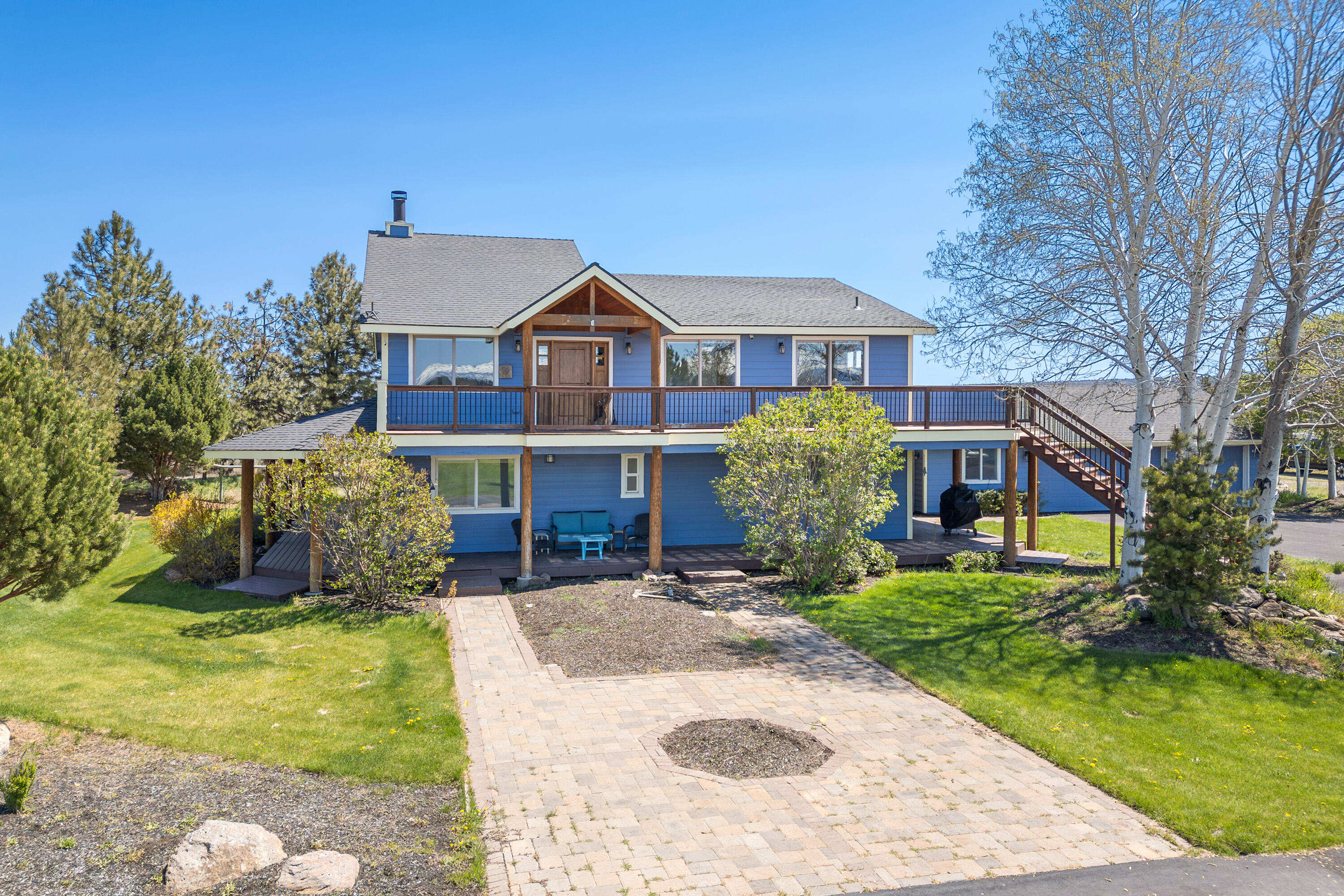 Incredible 9.5-acre property with panoramic, unobstructed Cascade Mountain views. The light-filled reverse-living floor plan showcases the big views from nearly every window. Upper level features vaulted ceilings, stone fireplace, and a spacious primary suite with walk-in closet, dual vanities, and tile shower. The kitchen includes ample cabinet and counter space, farmhouse sink, pantry, built-in fridge, and stainless steel appliances. Lower level offers a large family room, junior primary suite, and two guest rooms—ideal for multi-generational living. Outside, enjoy the view of the peaceful pond and the calming sounds of the water features from the wraparound porch! The property is fenced and cross-fenced with a riding area and animal stalls, offering space for horses, cattle, or future expansion. Plenty of room to build your dream barn or additional outbuildings. A rare combination of natural beauty, functionality, and opportunity.