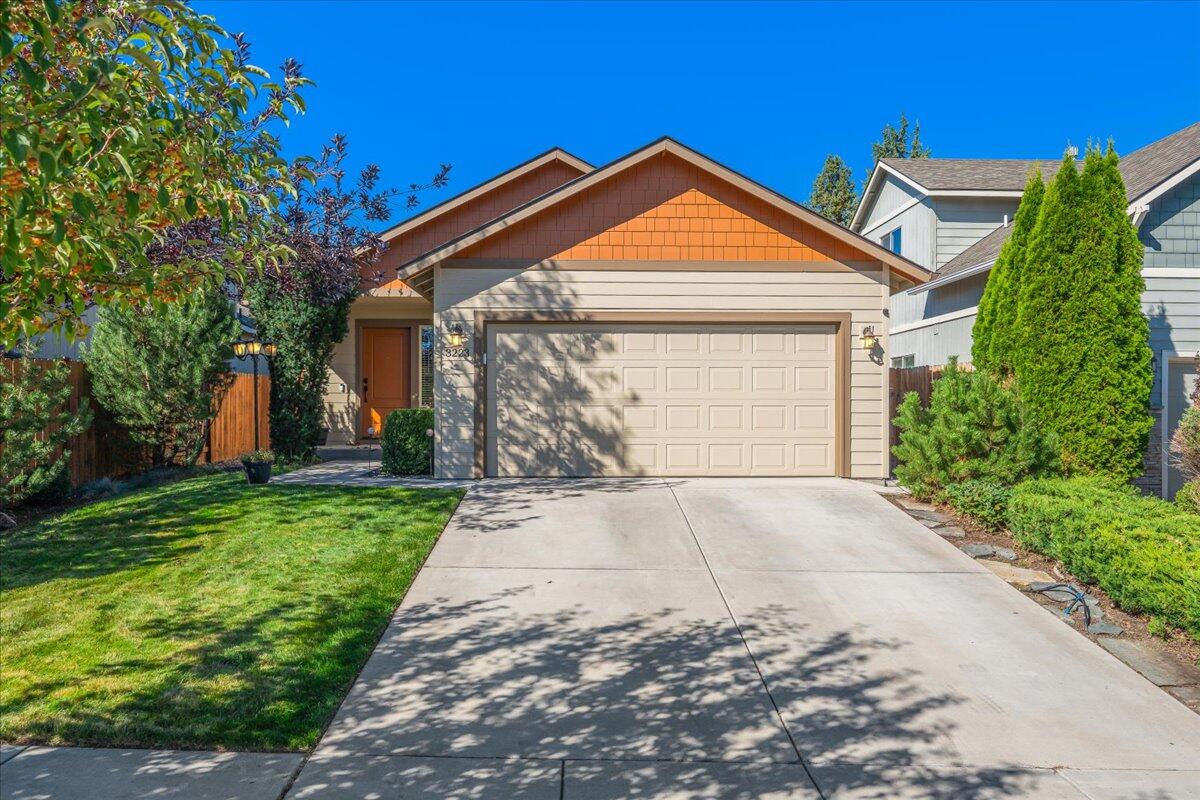 Discover the charm of this beautifully cared-for single-level home! The open-concept sets the stage with vaulted ceilings, a cozy gas fireplace, and expansive windows that fill the space with natural light, while hickory engineered hardwood floors add warmth and character. The kitchen shines with a large island, stainless steel appliances, quartz counters, and a modern tile backsplash - perfect for both everyday living and entertaining. The primary suite offers a quiet retreat with its own bath and sliding door to the backyard. Outside, you'll find mature landscaping, a covered patio, and raised garden beds - all within a fully fenced yard. The backyard feels wonderfully private! Additional highlights include a brand-new water heater and new garage stairs that provide easy access to extra attic storage. Set on a quiet street and ideally located near schools, shopping, and the hospital, this home offers both convenience and comfort.