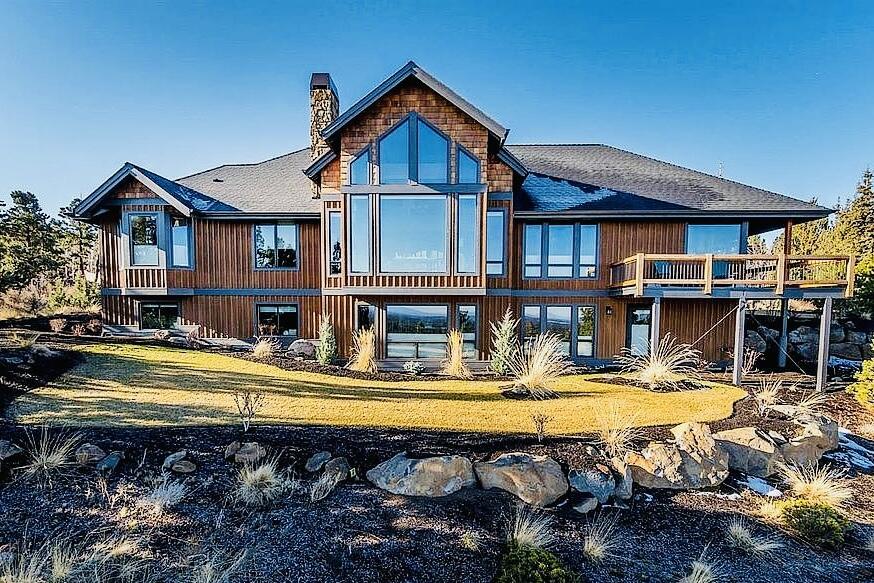 From the minute you walk in beautiful iron doors the views await!  Gorgeous modern craftsman perched on Awbrey Buttes best street.  This home offers spectacular views of the Cascade Mountains and Smith Rock.  The dramatic great room with vaulted mahogany wood ceilings welcomes you into open living spaces, a chef's kitchen, expansive office space, two bedrooms on the main level, including the master suite. The spacious primary suite includes a luxe bath, radiant floors, and a walk-in closet.   Perfect for families, the home features views from every room with a sun-filled lower level.  Generous entertaining areas, a theater room, three bedrooms, and abundant storage. Three-car garage, two large lawn areas, and natural landscaping complete this exceptional family home.   The wrap-around deck and entertaining areas will keep you outdoors all year long. On School route so street is plowed in the winter, L-shaped driveway has a minimal incline for safe snow driving. SONOS system throughout