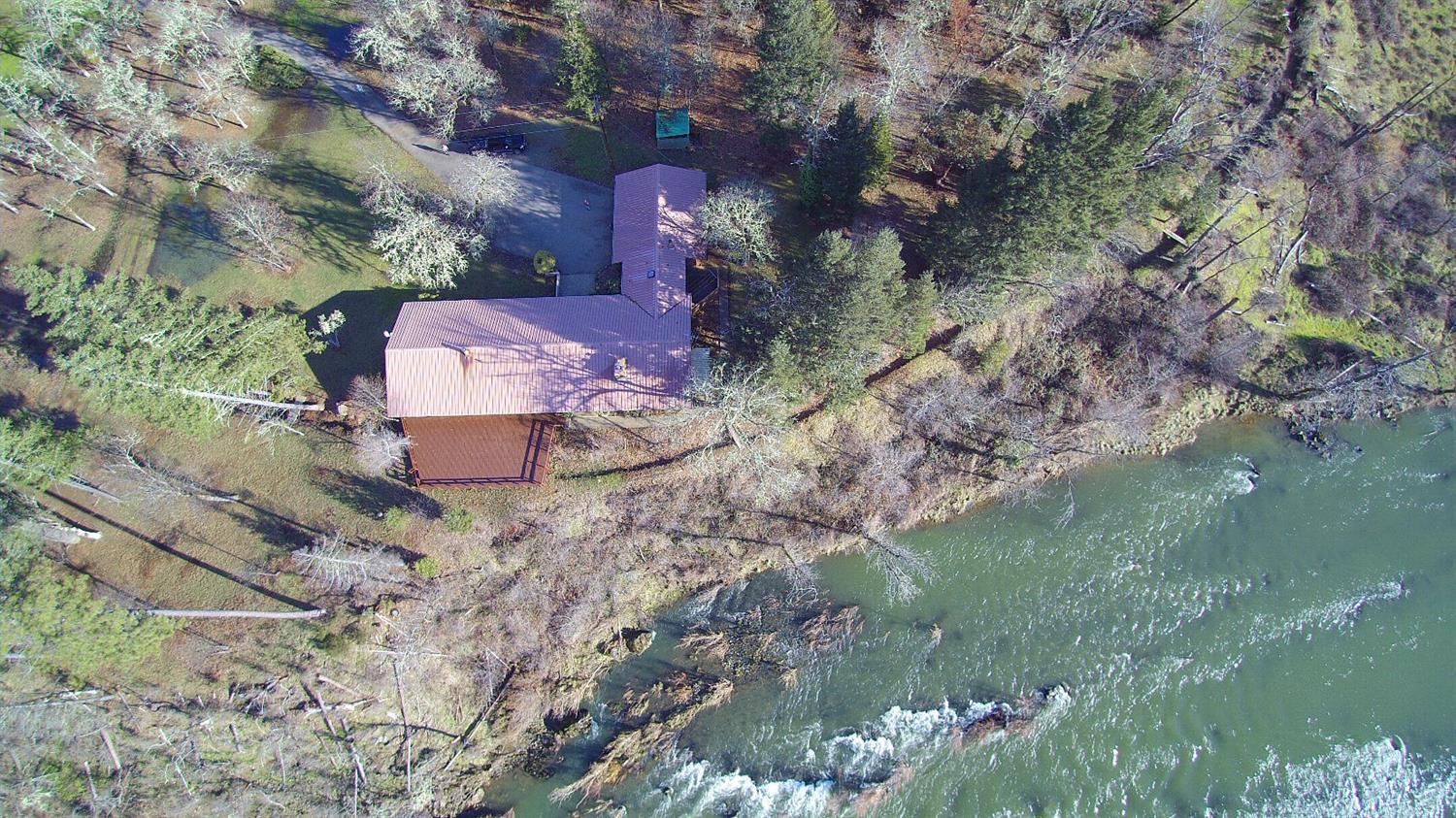 At nearly 3/4 of a mile river frontage, this private 99.66 acres will exceed your expectations with all it has to offer. Nestled along the beautiful Illinois river, close to town, but with a total country feeling. Coupled with 62.1 acres of water rights and loads of land the possibilities are endless; cattle, horses, farming, vineyard, multifamily set up or weekend retreats. The main home is 2974 sq/ft, with abundant windows to take in the majestic river views. Four of the bedrooms have sliding glass doors that go out onto a 1000 + sq/ft deck that looks right down on the river. There is a legal 560 sq/ft rustic cabin, a non-conforming workhouse, multiple outbuildings, barn, cattle corral, older concert tennis/basketball court, epic swimming holes, 3 phase power to main 40 hp irrigation pump, fully fenced & cross fenced. To much to list, call for your tour today. Information deemed accurate, but not verified. Buyer to do own due diligence regarding all aspect & uses of this property.
